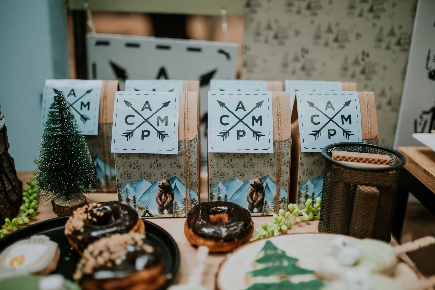 Rustic wedding ceremony decor features wooden signs with minimalist arrow designs and floral arrangements on tree stumps.