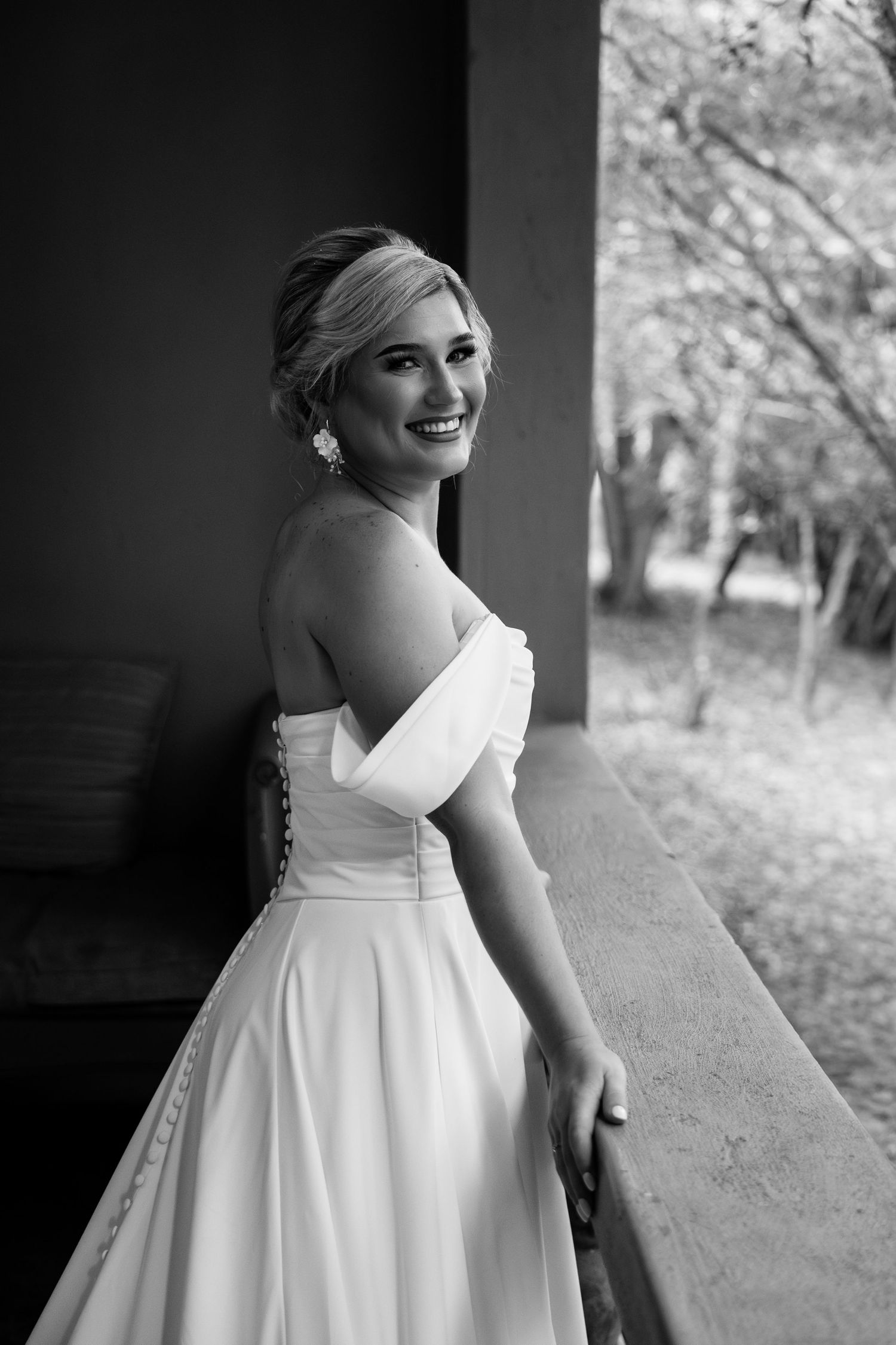 A series of black and white photos showing a person in a white wedding dress posing against a rustic background.