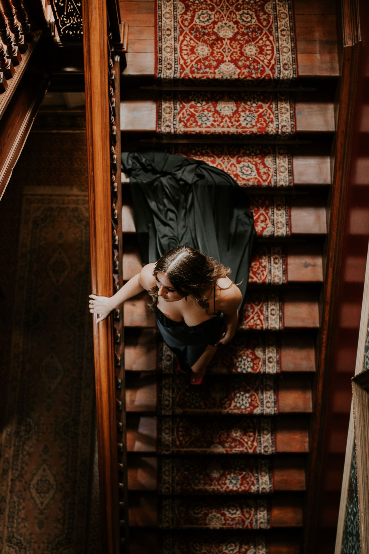 A series of connected photos showing someone climbing up ornate carpeted stairs in a dark wooden stairwell.