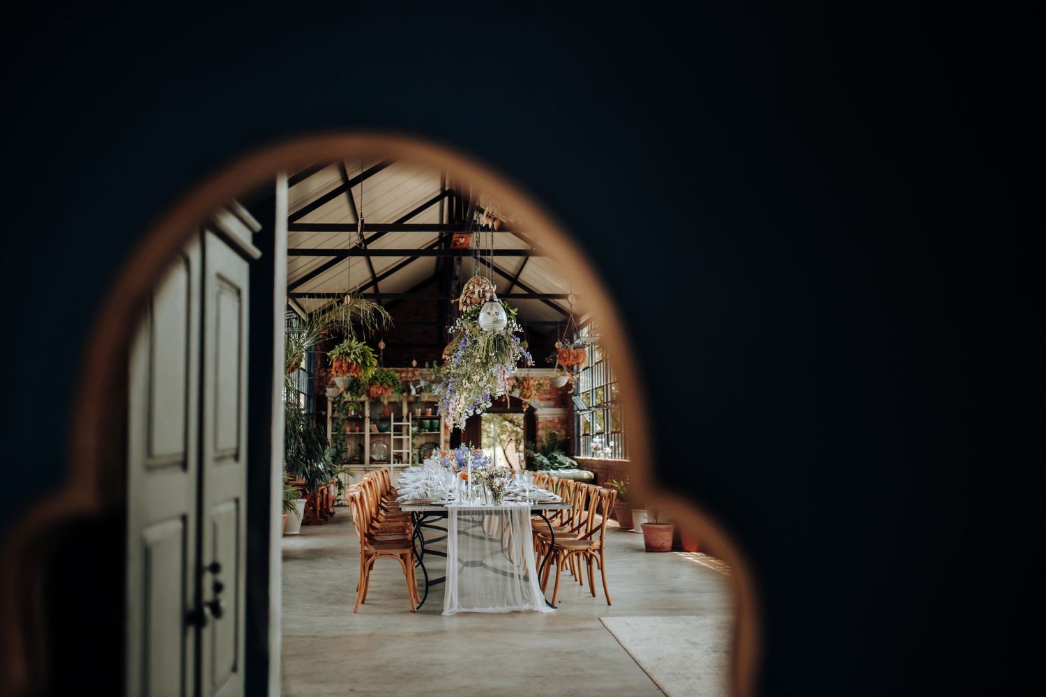 A sequence of cinematic wedding photography shots showing a ceremony setup through various archway frames.