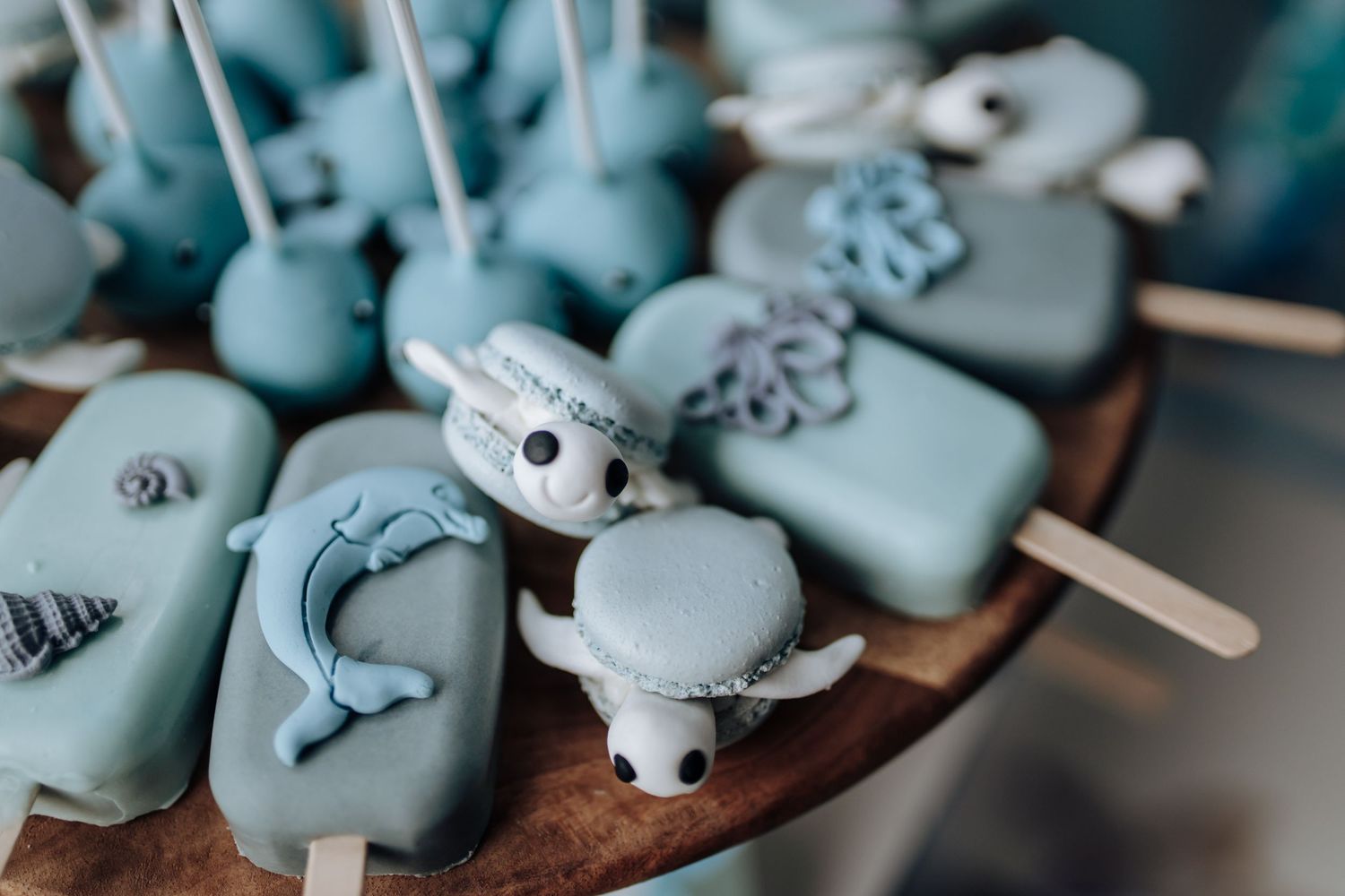 Handcrafted light blue ceramic tea pets in various animal shapes displayed together on a wooden surface.