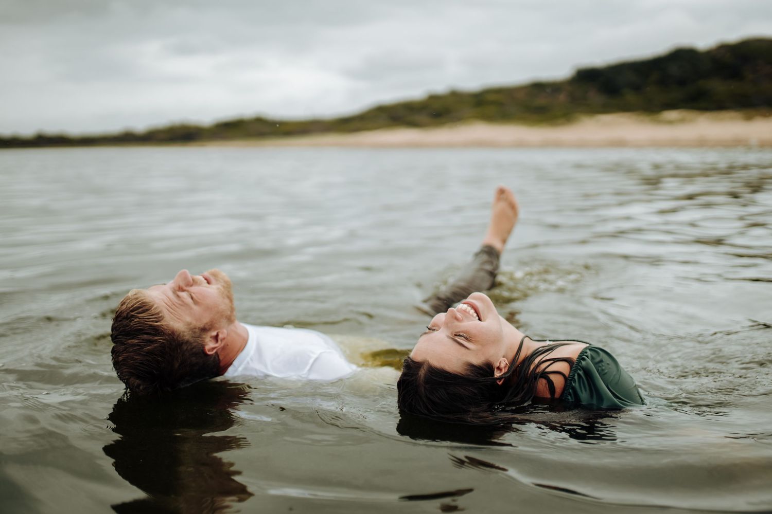 Woman floating peacefully in tranquil water with hair flowing around her face.