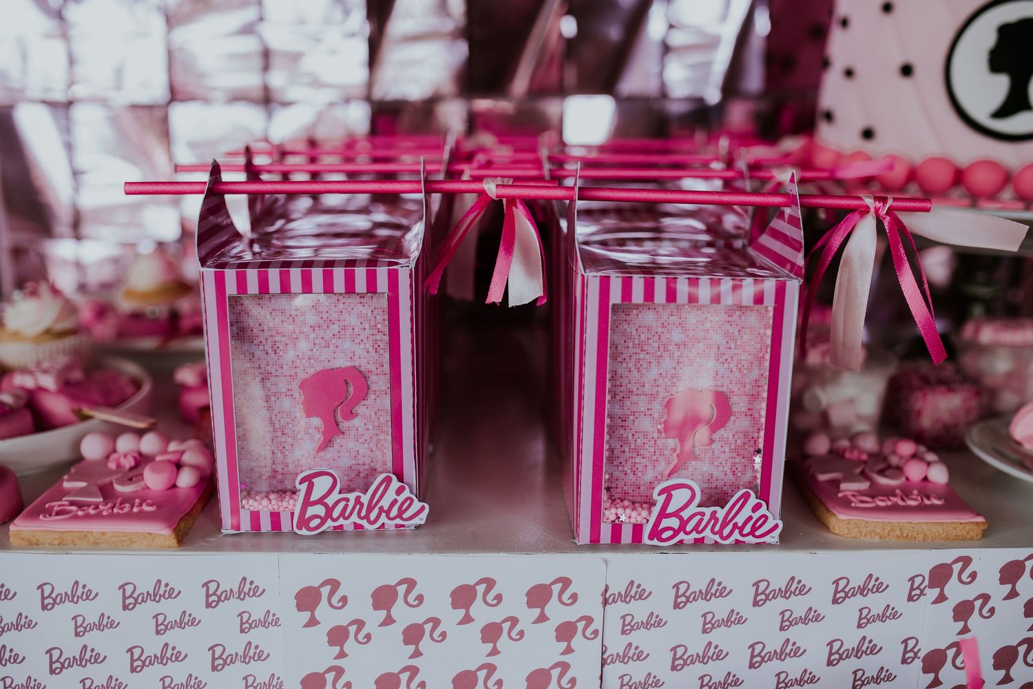 Pink Barbie-themed retail display shelves filled with merchandise and toys at a shopping store.