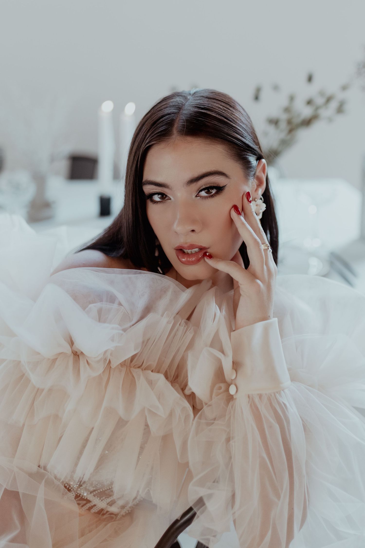 A figure wearing a delicate sheer white ruffled outfit poses gracefully across a series of artistic close-up shots.