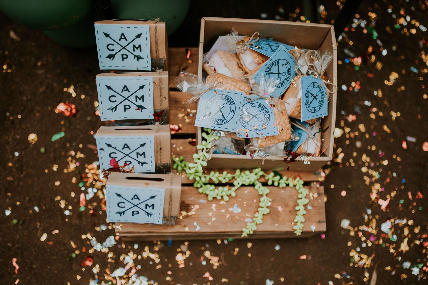 Blue boxes with cookies and sprinkles scattered on a rustic wooden surface in moody lighting.
