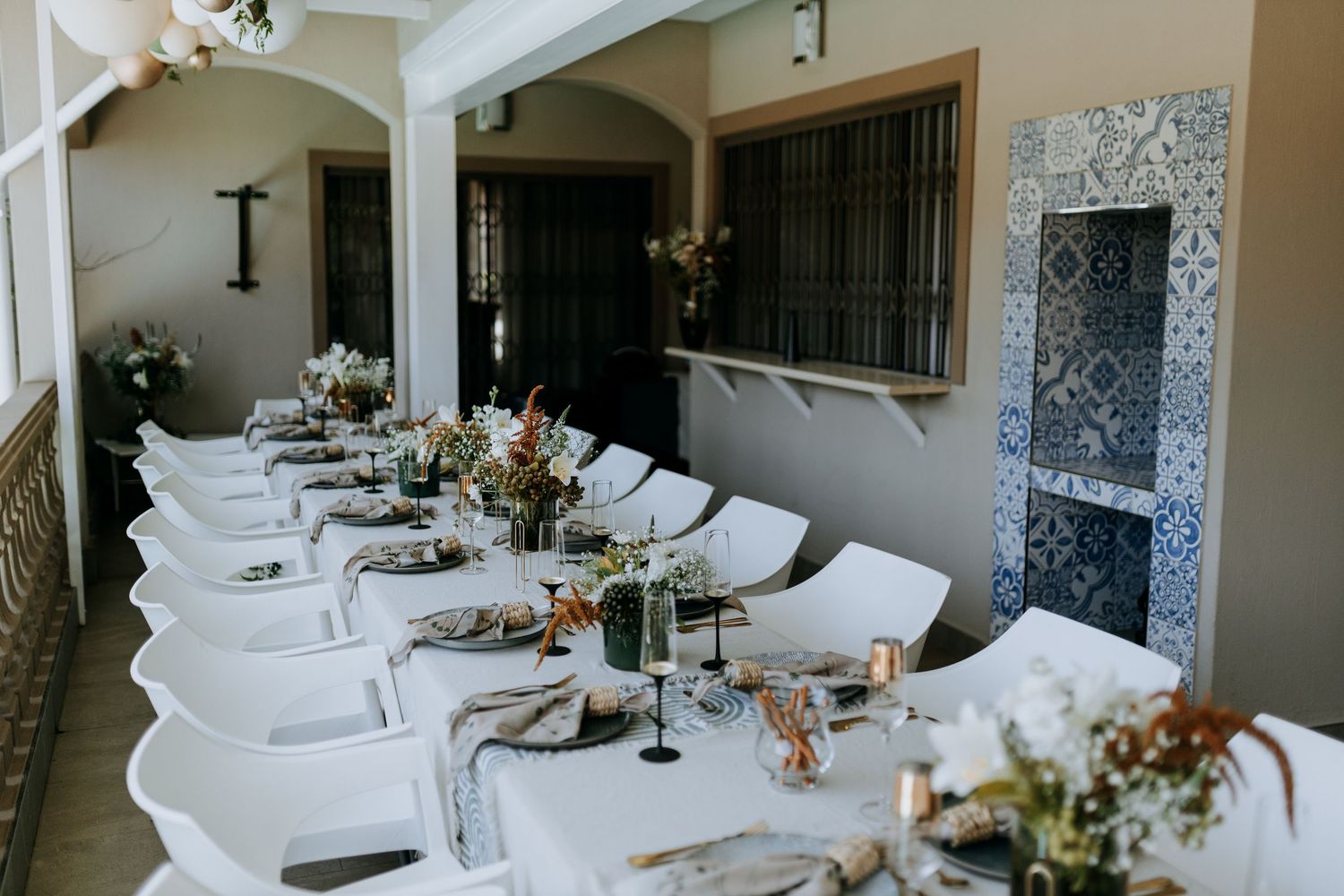 Elegant white dining table settings with floral centerpieces in a modern restaurant space.