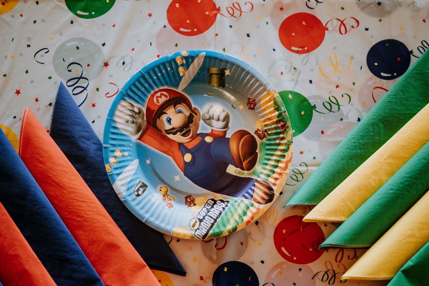 Party plates with colorful streamers and confetti dots decorating the festive table for a celebration.