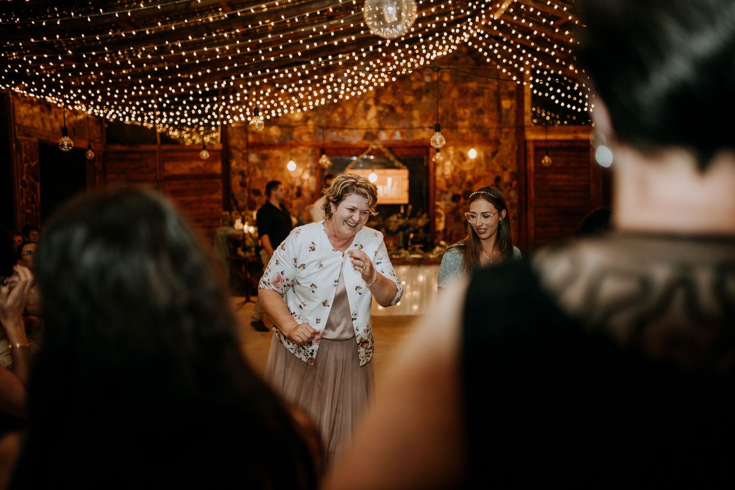 Wedding celebration at night with romantic string lights and lanterns creating a warm, glowing atmosphere.