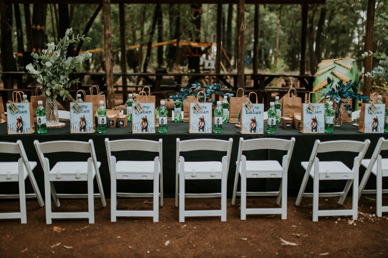 Wedding ceremony outdoor setup with folding chairs and floral decorations on a sunny day in a garden setting.