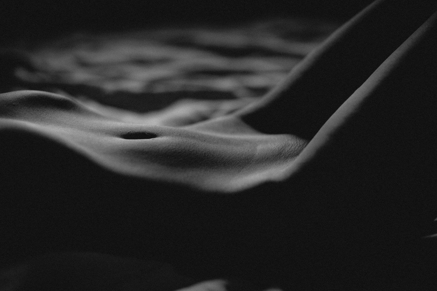 Close-up black and white body photograph exploring texture, light, and natural form.