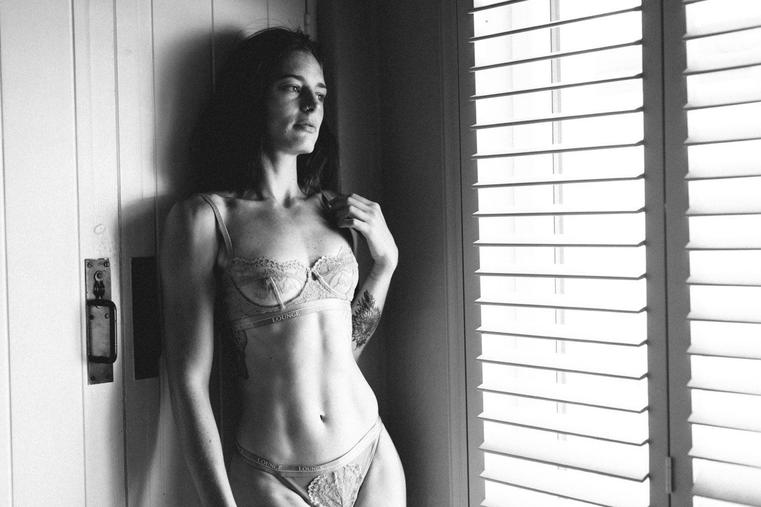 Black and white Fitness inspired photograph of a woman showcasing sculpted core and posture.