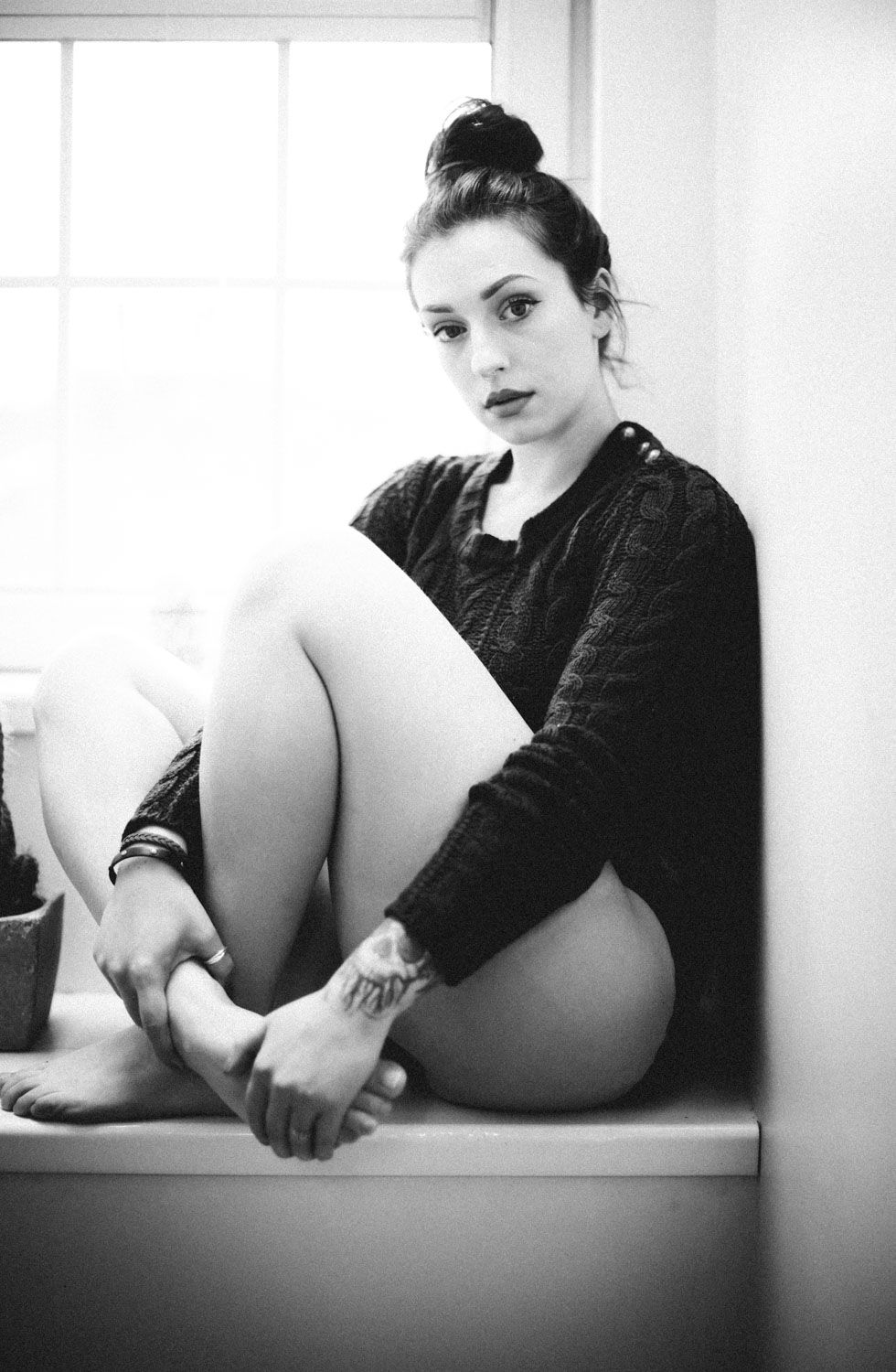 Monochrome Irish female portrait with elegant lighting and timeless style of woman sitting near window.