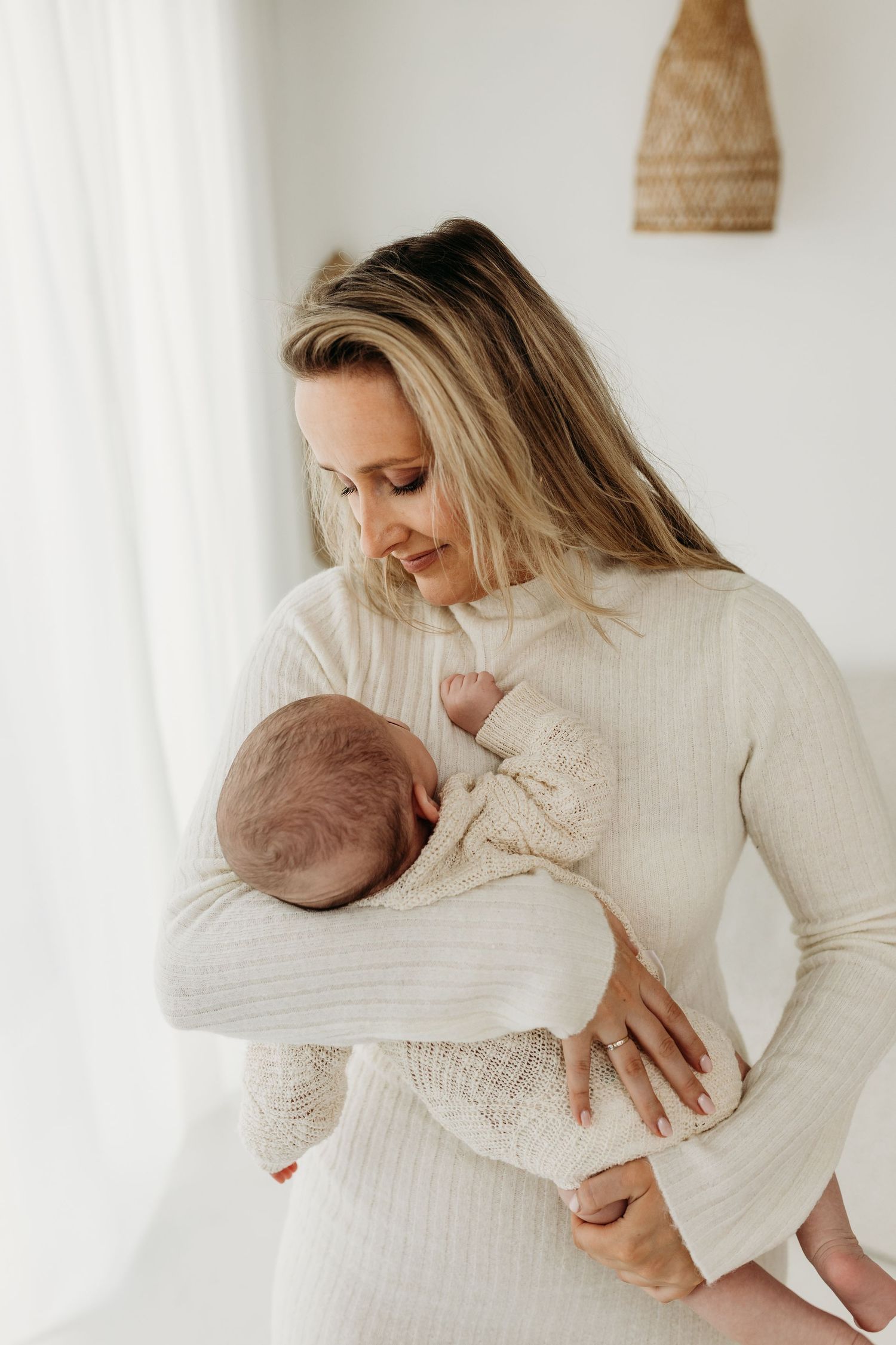 Intieme zwangerschapsfotografie van een moeder in een lichte studio met natuurlijke tinten en rust.