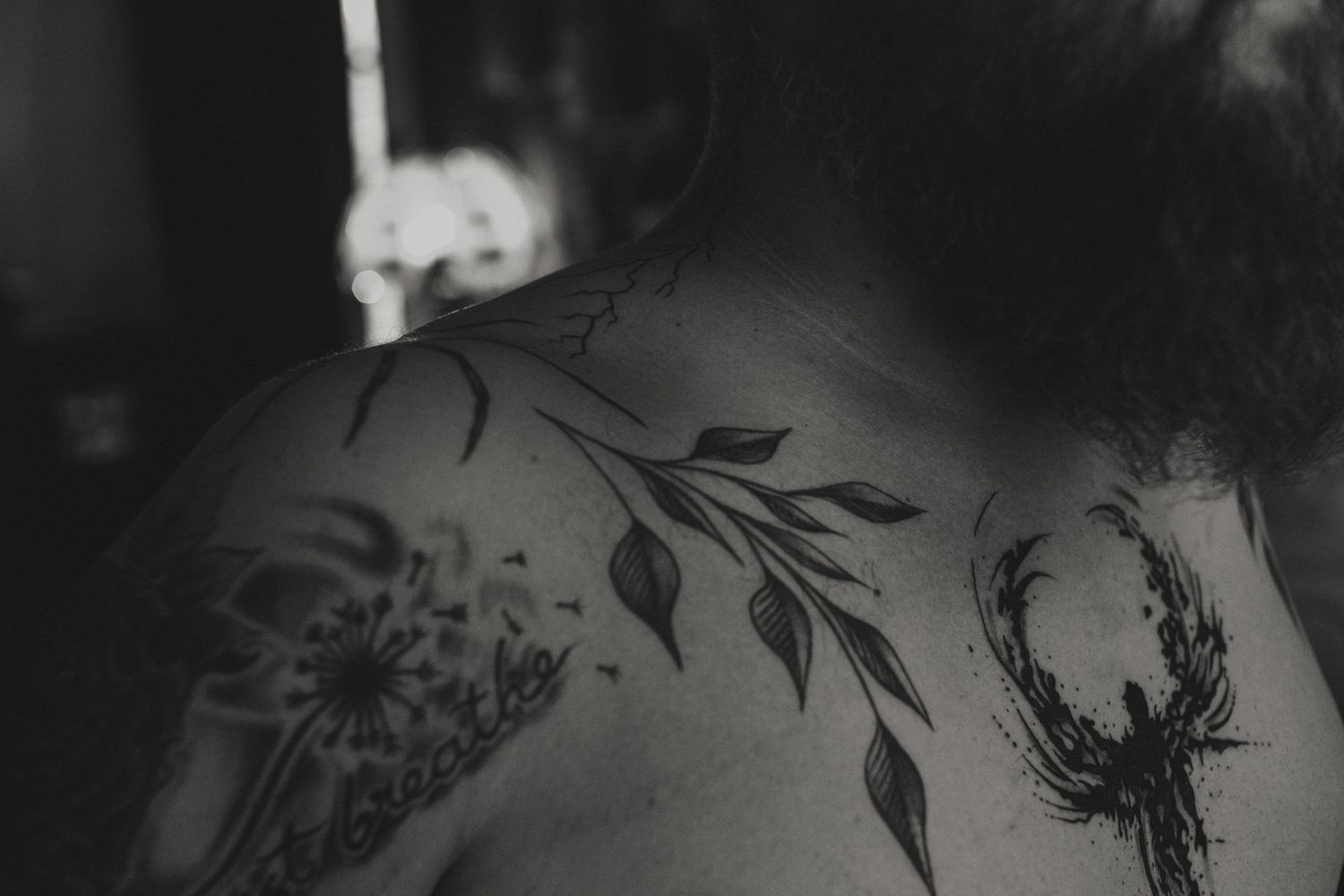 Black and white close-up of tattoos showing delicate floral and leaf designs on skin. Sierra Vista Boudoir Photographer.