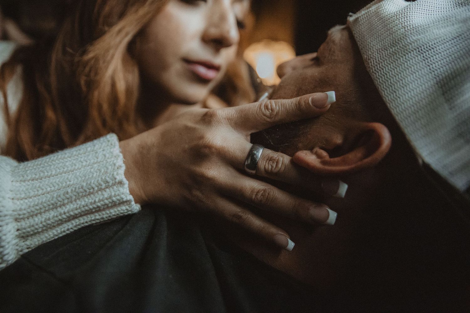 Person holding a steaming cup of coffee in a cozy sweater against a warm neutral background. Tucson couples boudoir.
