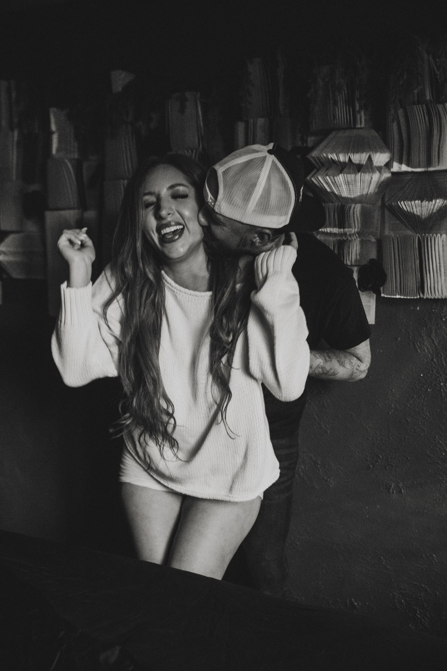 Black and white photo sequence showing a person in a white top dancing and moving expressively in dim lighting. Tucson couples boudoir.