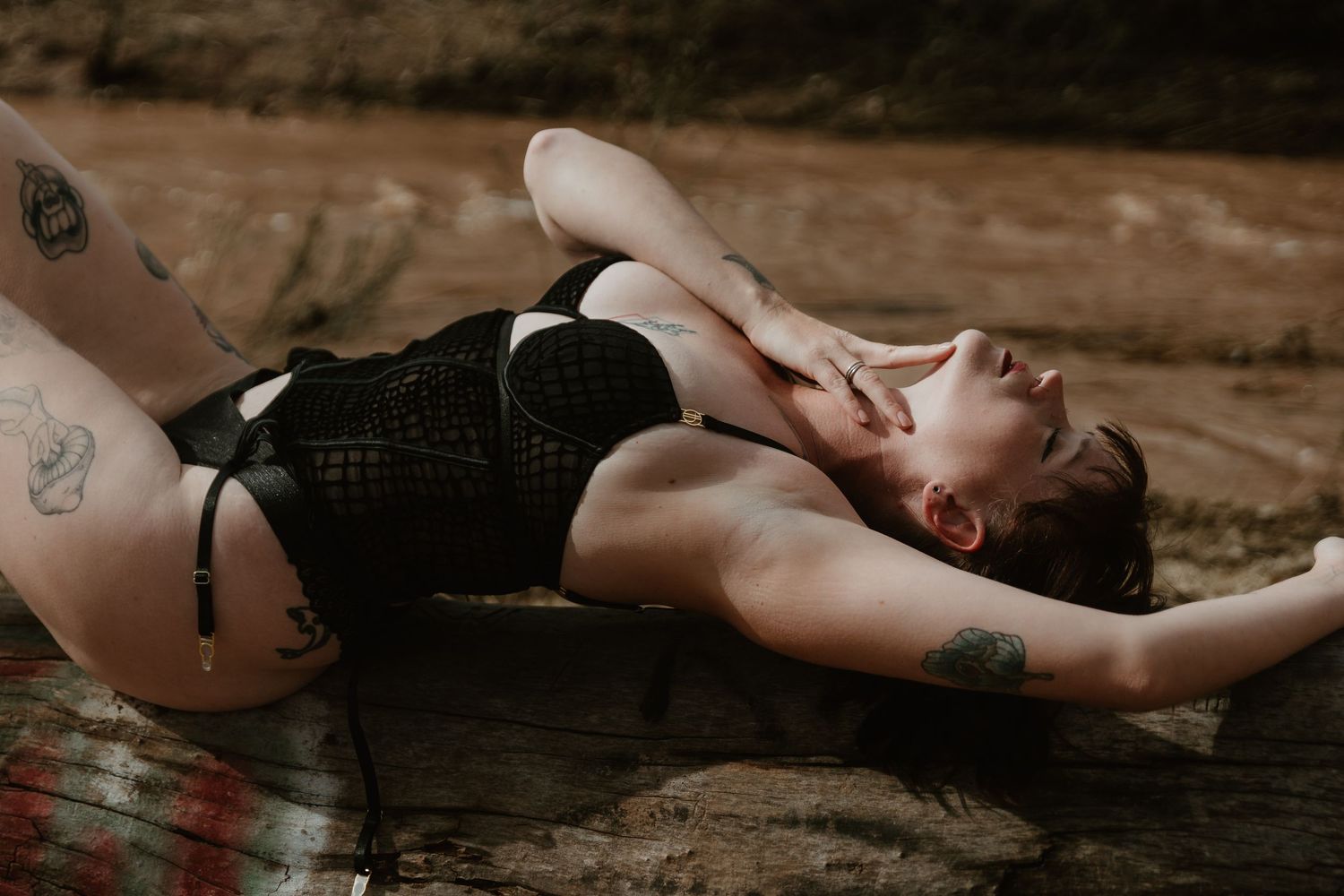 Two people lying on a wooden deck in a romantic pose during sunset. Tucson boudoir.