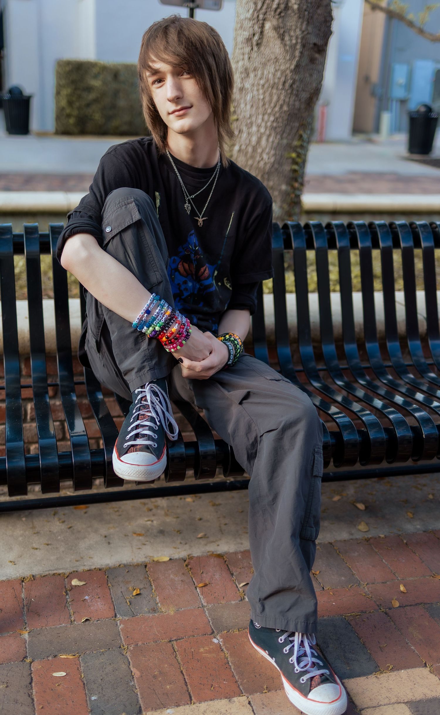 Person sitting on park bench wearing gray pants and colorful Converse sneakers showing different poses.
