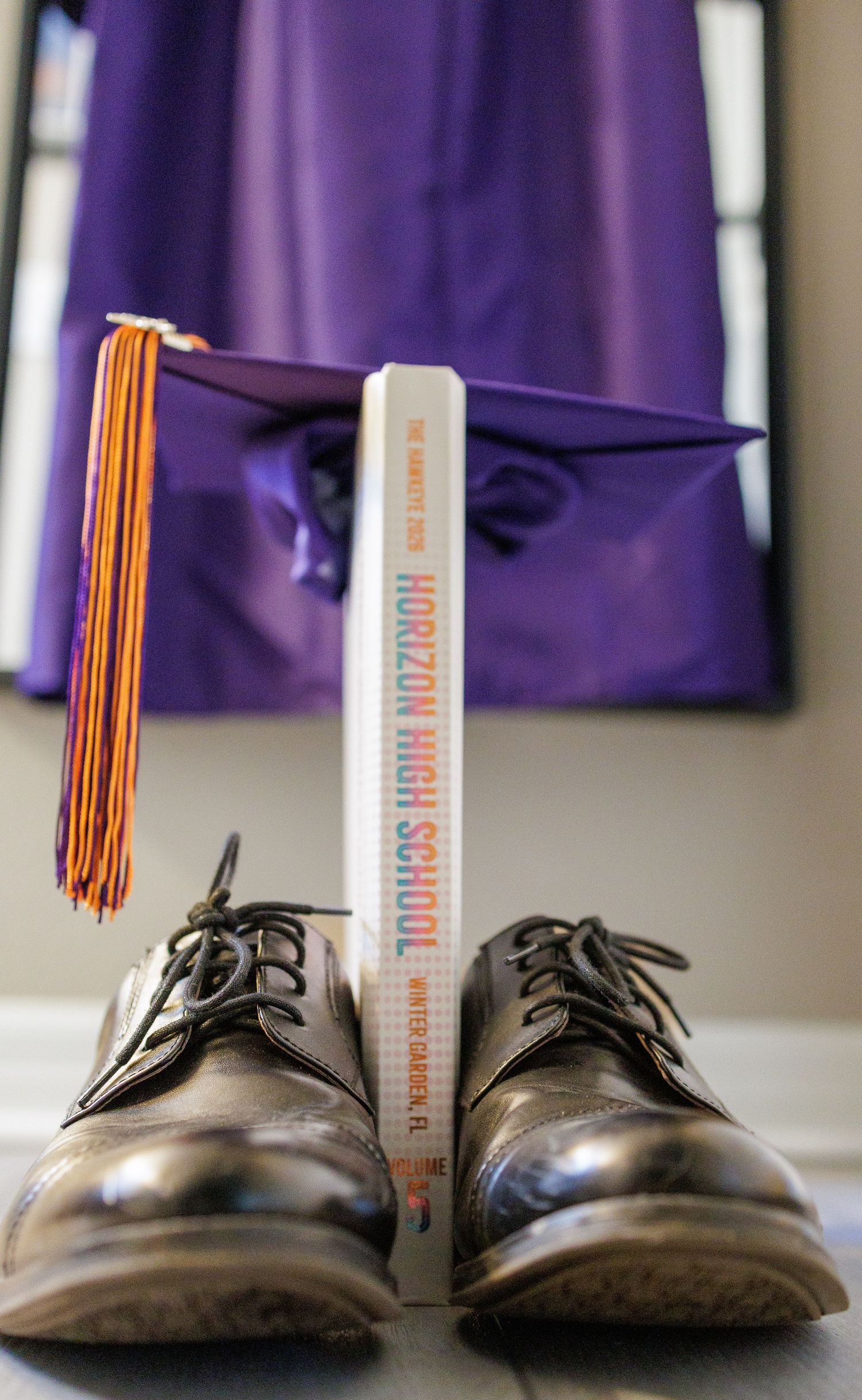 Horizon High School graduation cap and gown with dress shoes and yearbook, Winter Garden FL commencement ceremony.