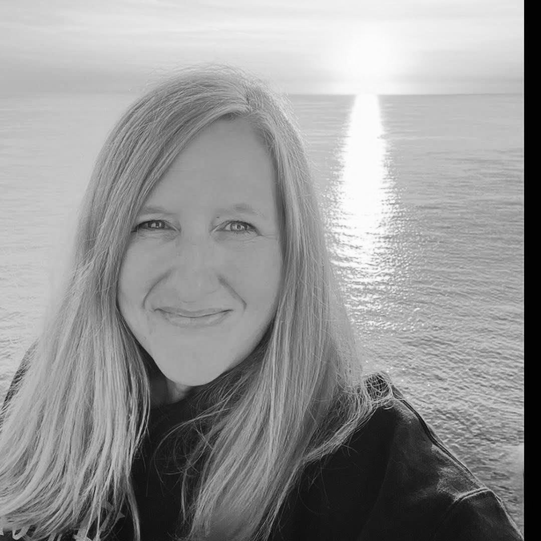 Black and white selfie series of a person with long blonde hair smiling against an ocean backdrop on a sunny day.