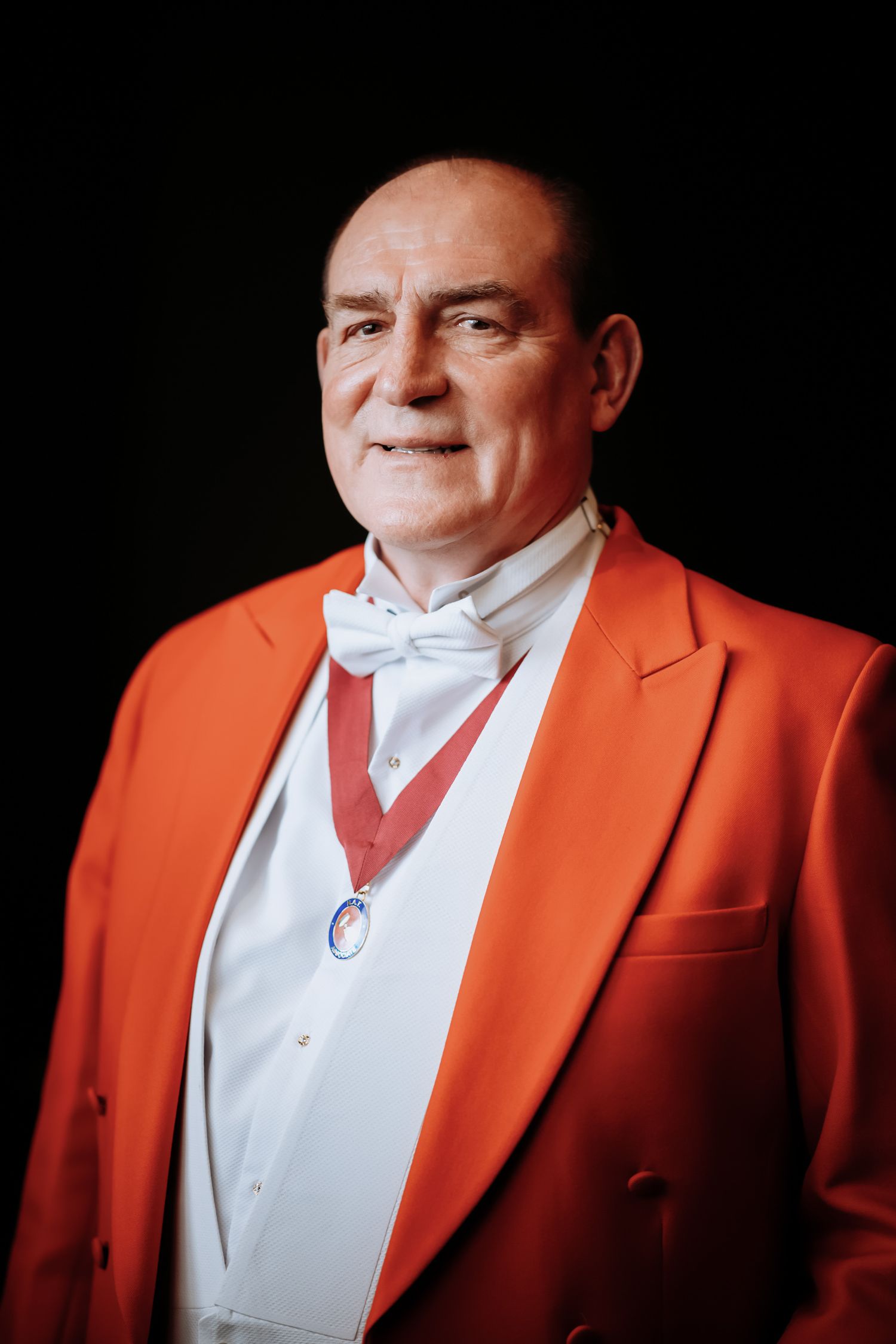 Professional portrait session in Cambridge for a local toastmaster in a stylish orange blazer.