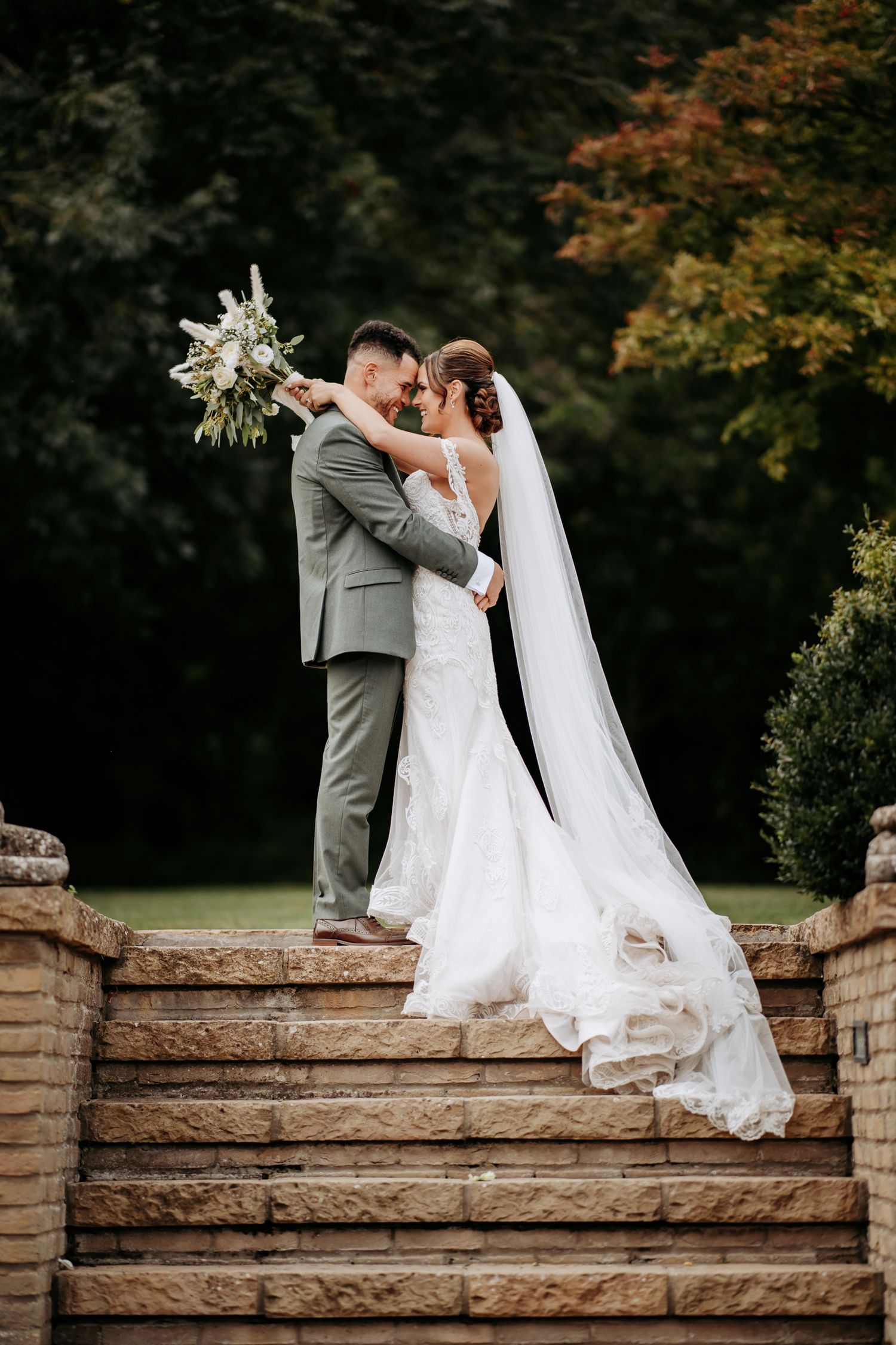 Wedding couple on the steps at Fulbourn Lodge, Cambridgeshire.