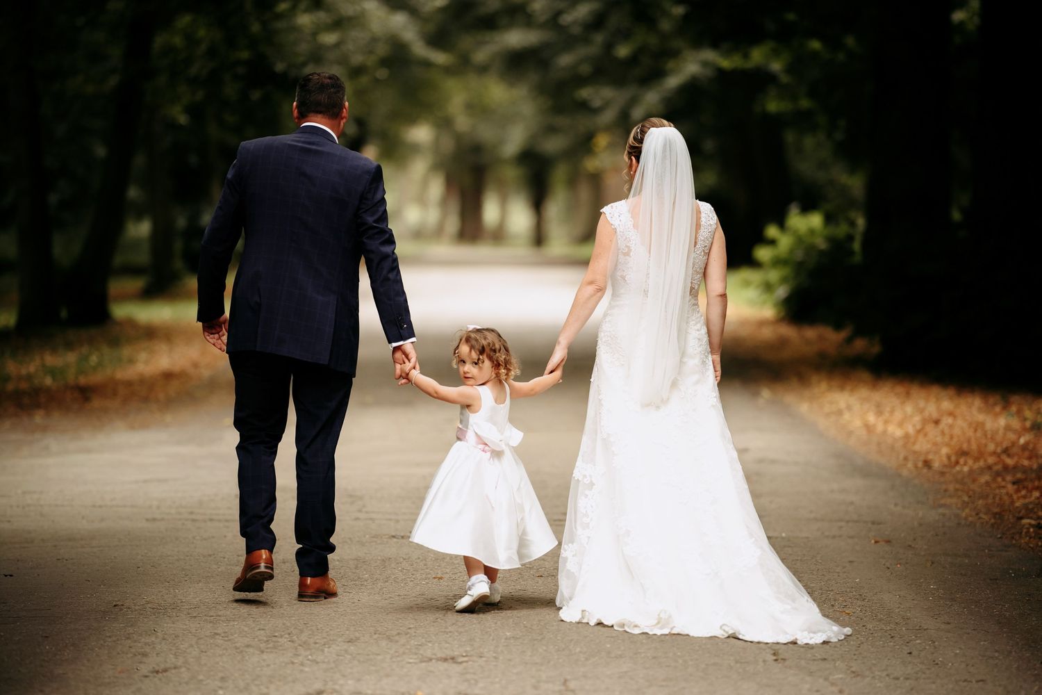 Couple walking with their child after a barn wedding at Blackthorpe.