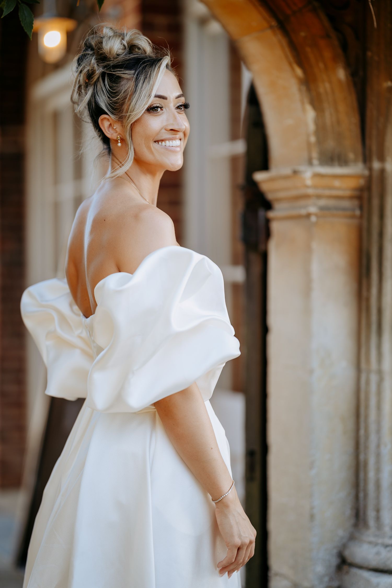 Stunning bride photo under arches with natural light at Longstowe Hall.