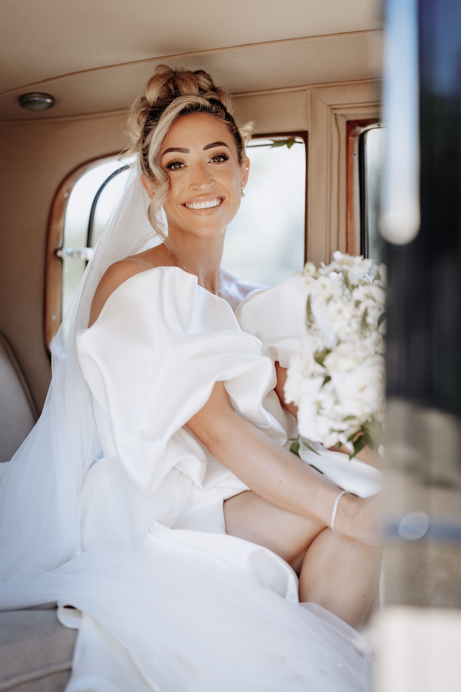Bride travelling to Longstowe Hall wedding in a luxury car.