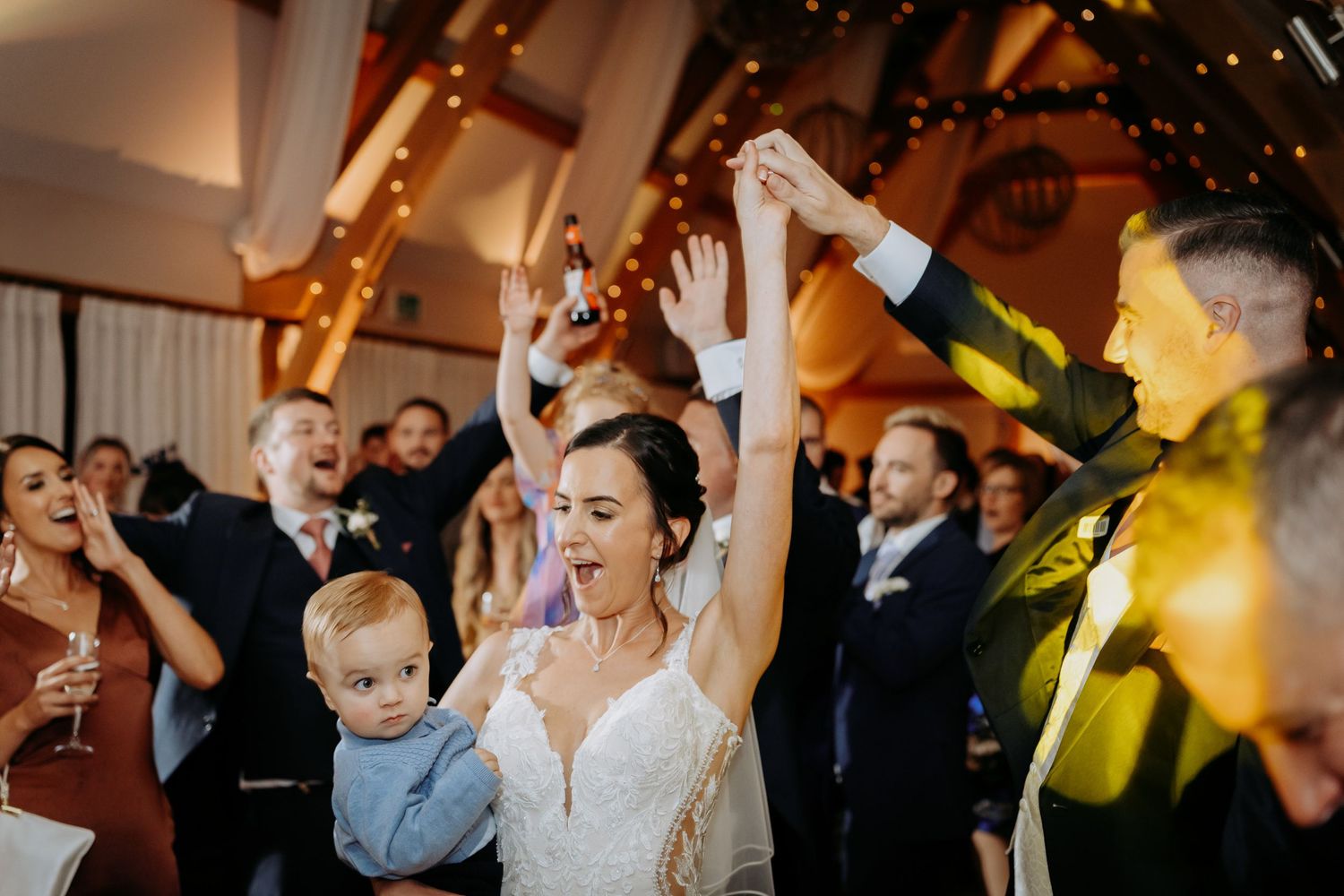 First dance wedding party photo with bride and groom in the main barn at Bassmead Manor, St Neots, Cambridgeshire.