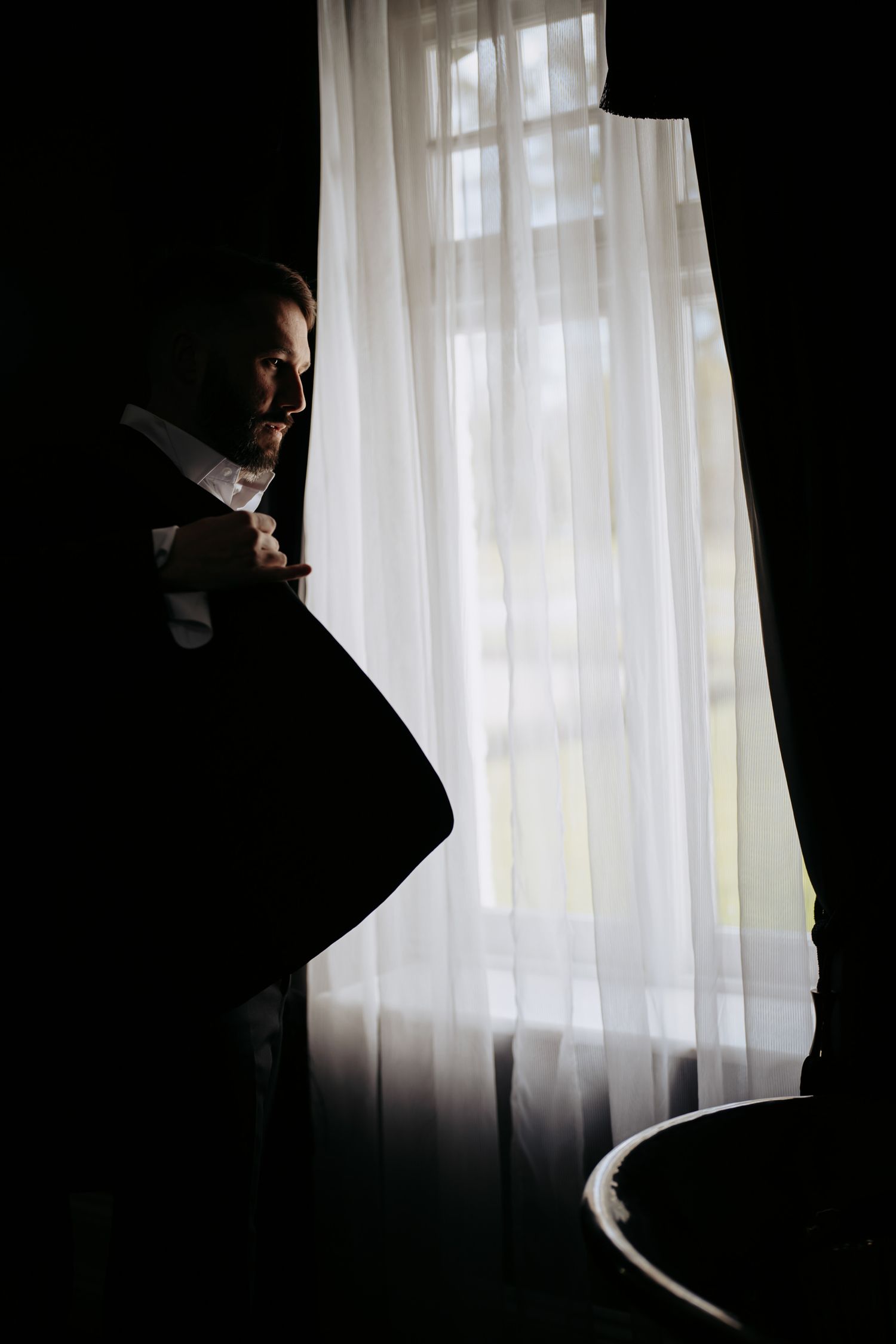 A silhouetted groom stands in dramatic contrast against a window at Swynford Manor Newmarket.