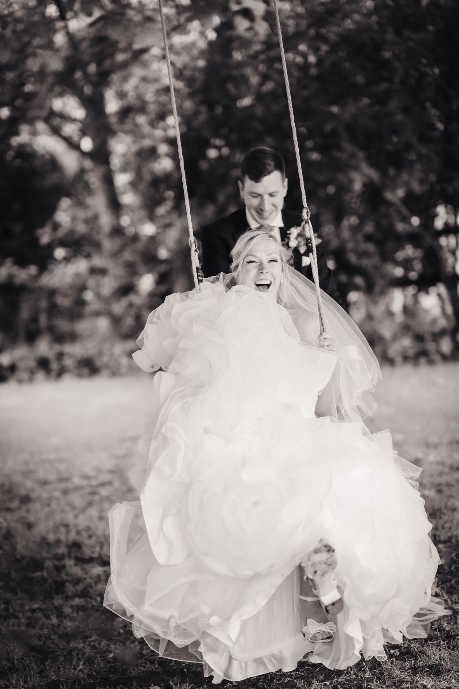 Award-winning black and white bride on a tree swing in Cambridgeshire.