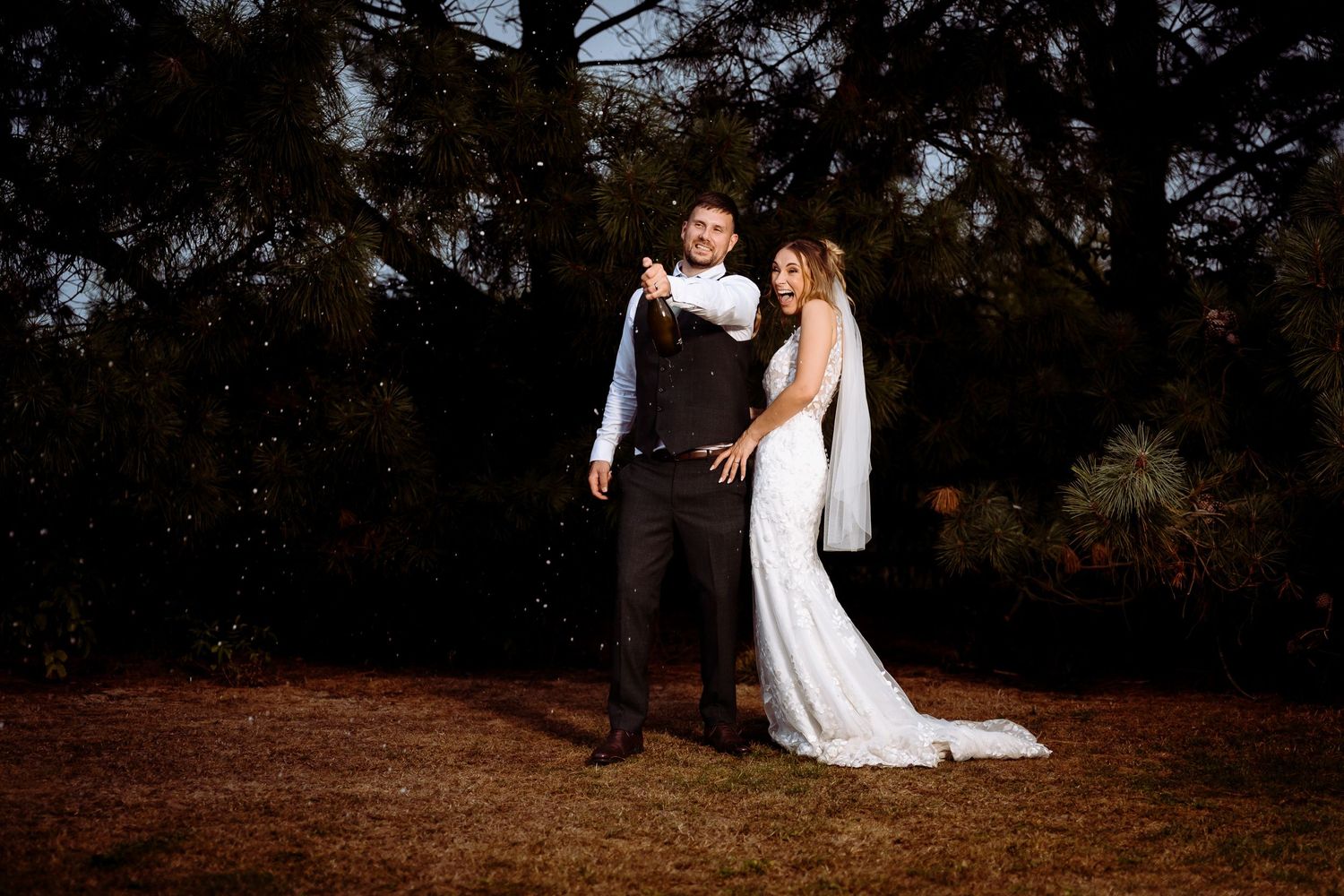Creative champagne spray night photo at a Northampton wedding.