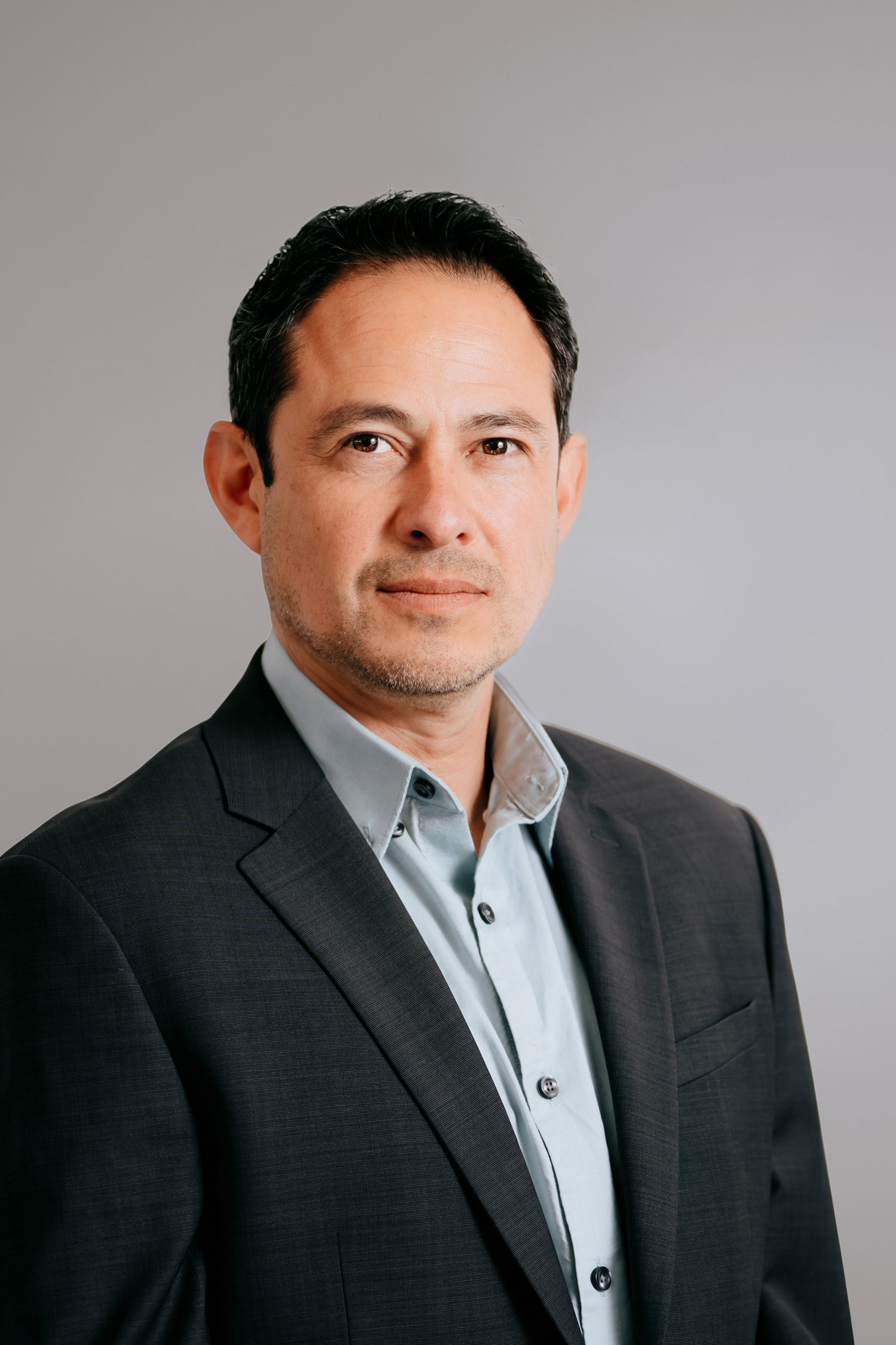 Male corporate headshot in suit and shirt for a formal business profile.