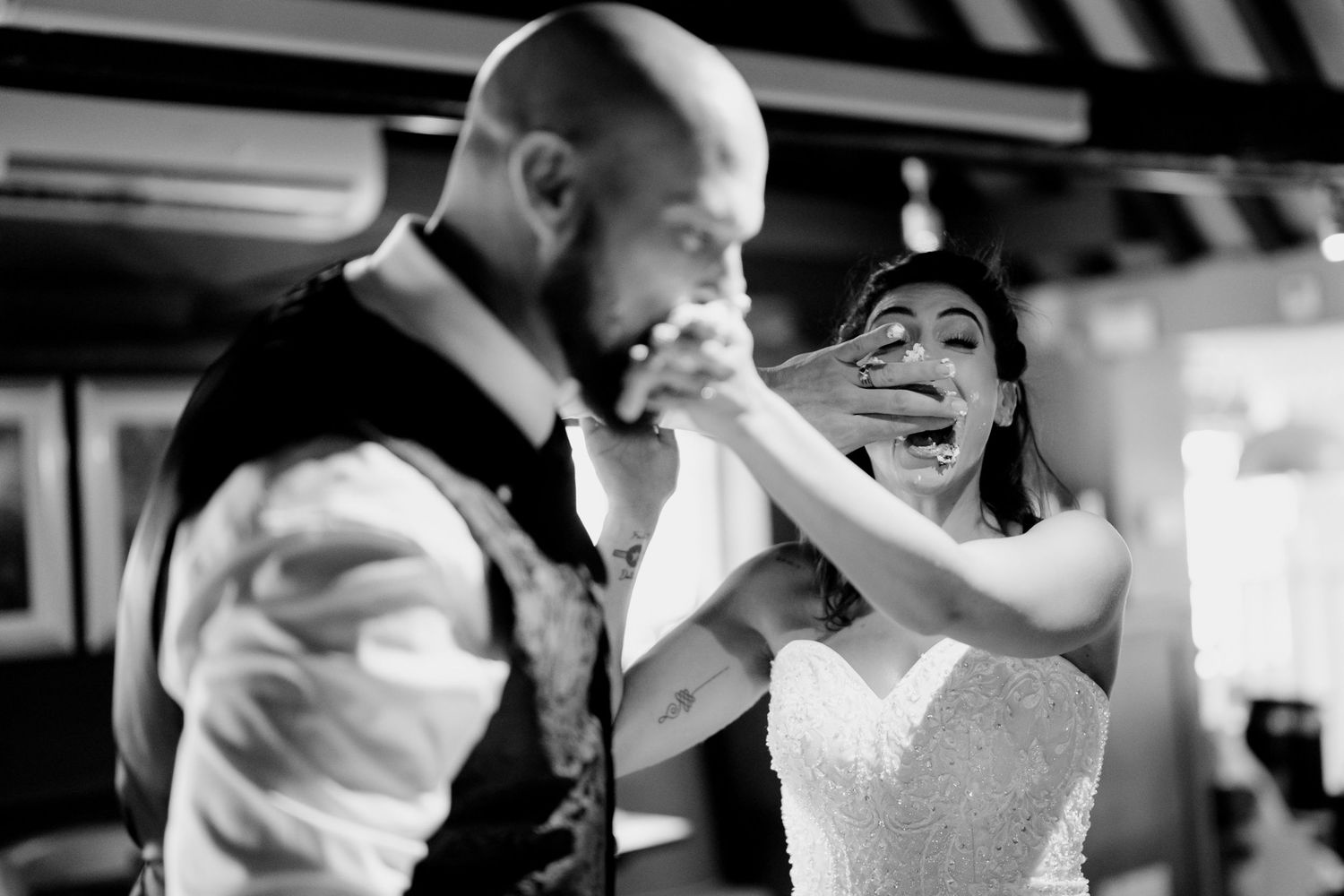 A black and white image showing a couple feeding cake to each other wedding in Huntingdon.