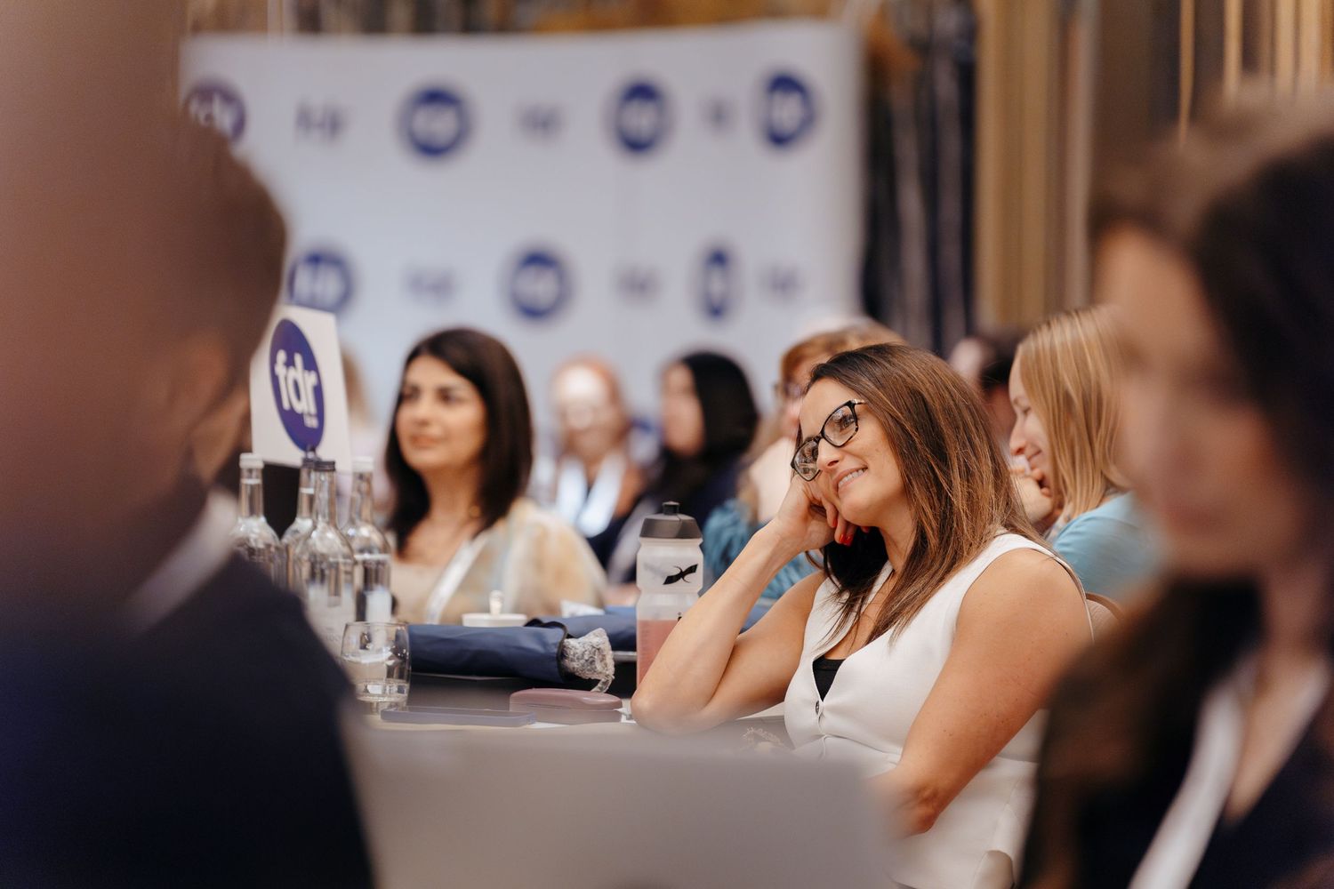 Photography of a conference breakout session with delegates seated at tables.
