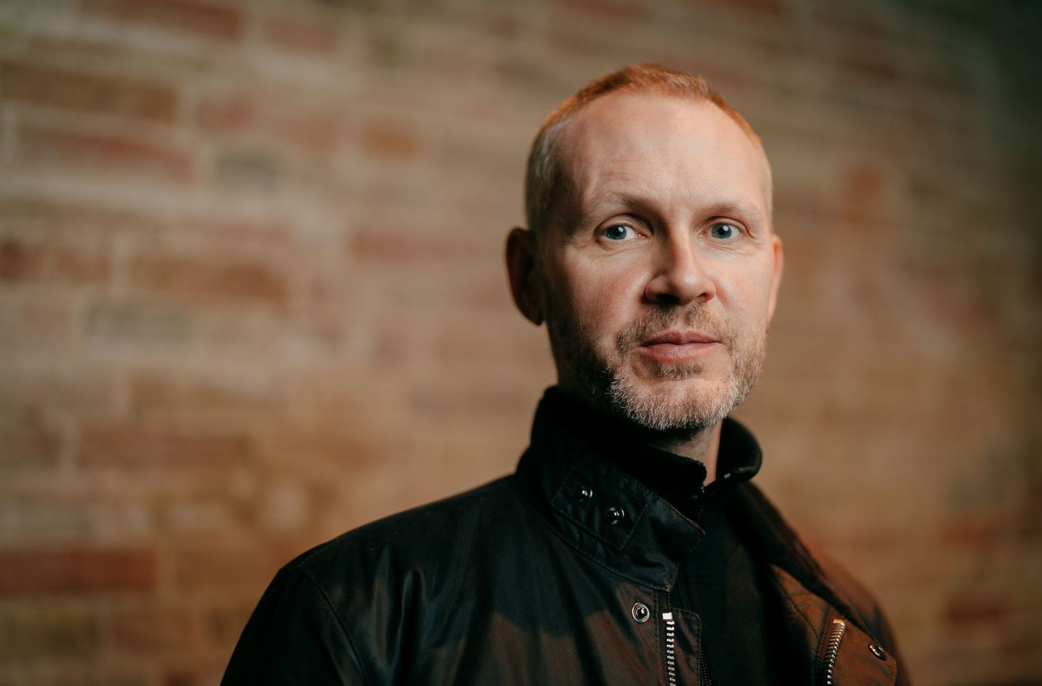 Local DJ headshot for press and PR campaign in Cambridgeshire featuring a brick wall background.