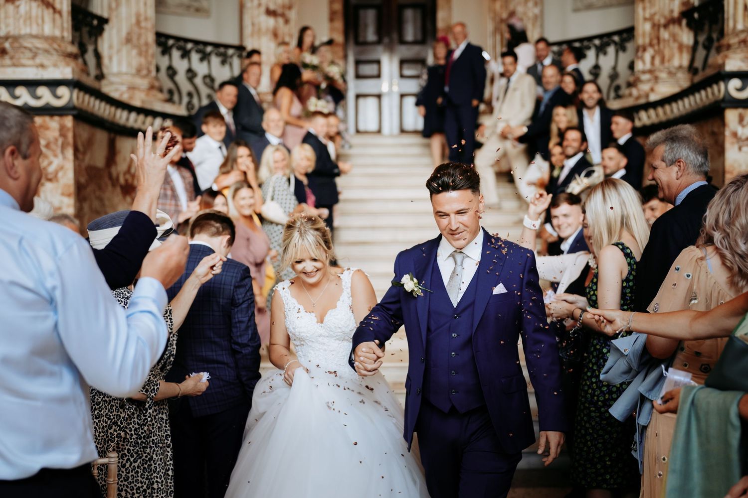Confetti run on the stairs at a grand hall wedding in Cambridge.