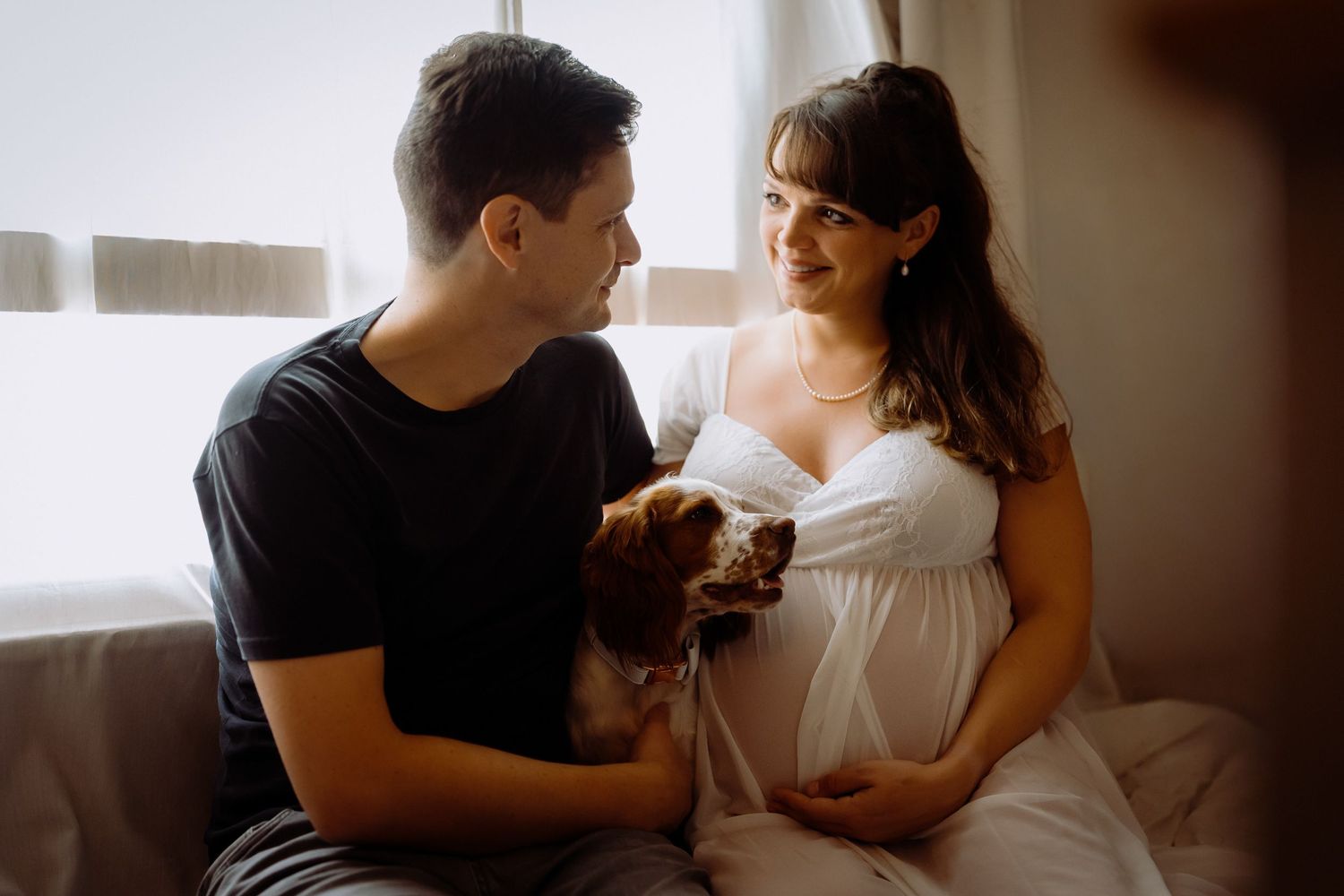 Natural maternity portrait photography in Cambridge featuring a relaxed couple on a couch.