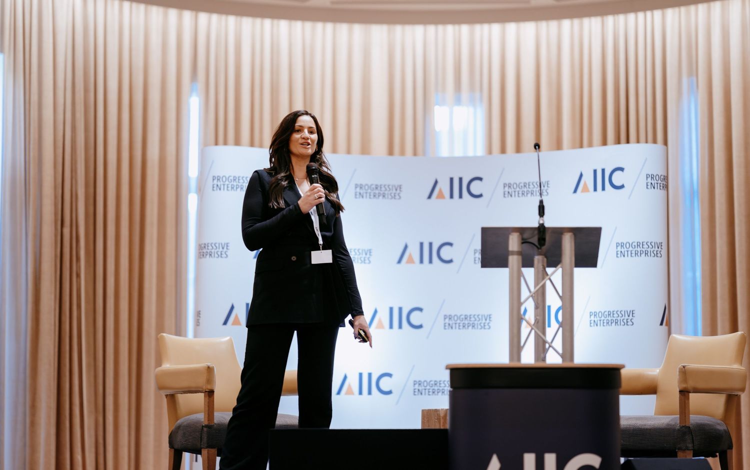 Guest speaker on stage at a corporate seminar in Cambridge.