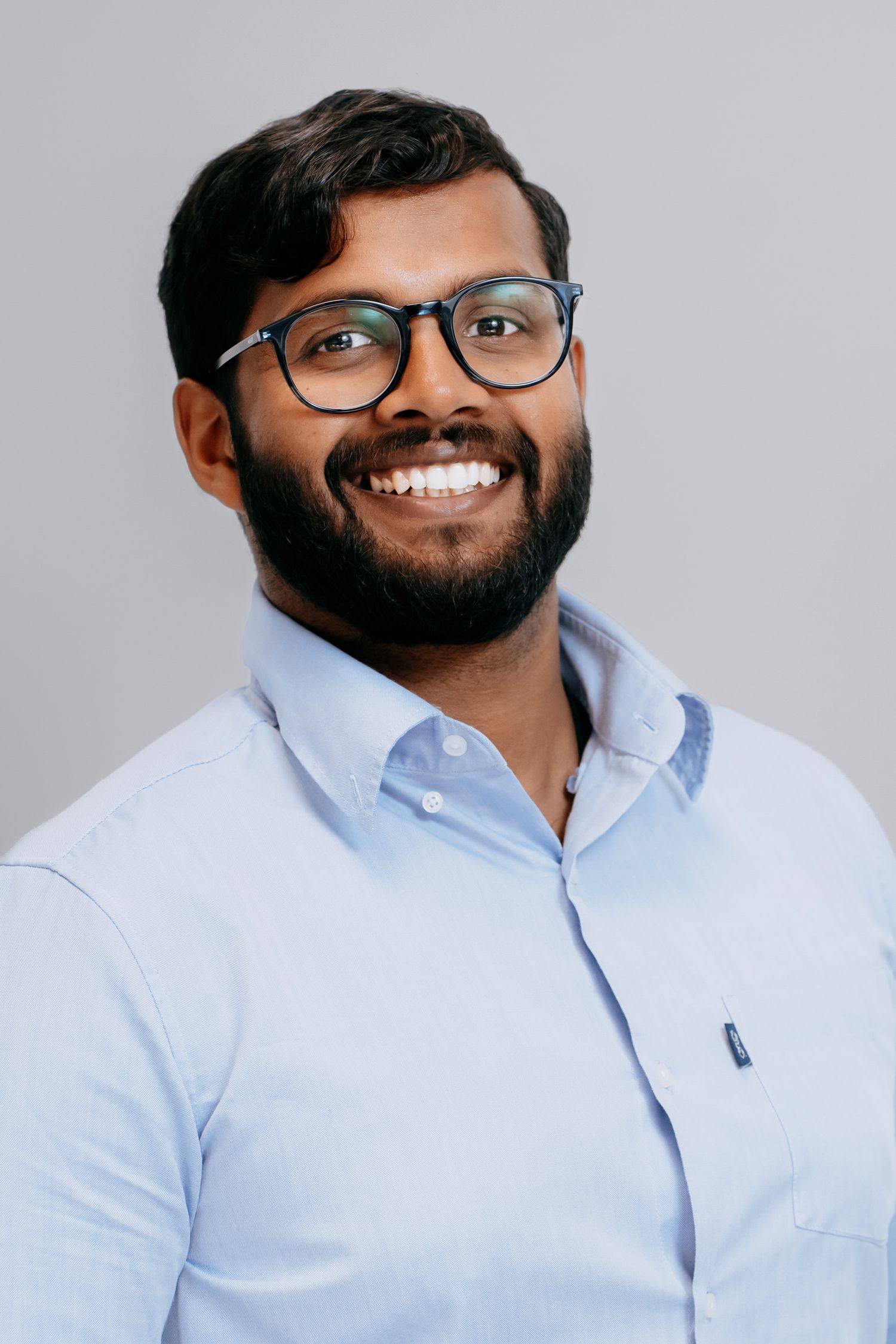 Studio headshot on grey background with professional lighting.