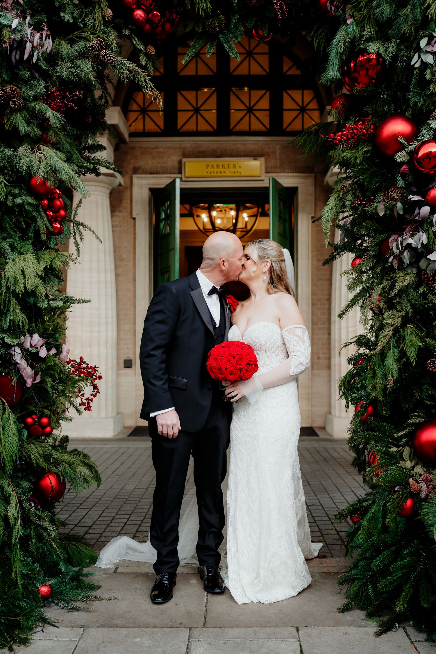 Wedding couple shares romantic photo under festive Christmas decorations at Parkers Tavern Cambridge.