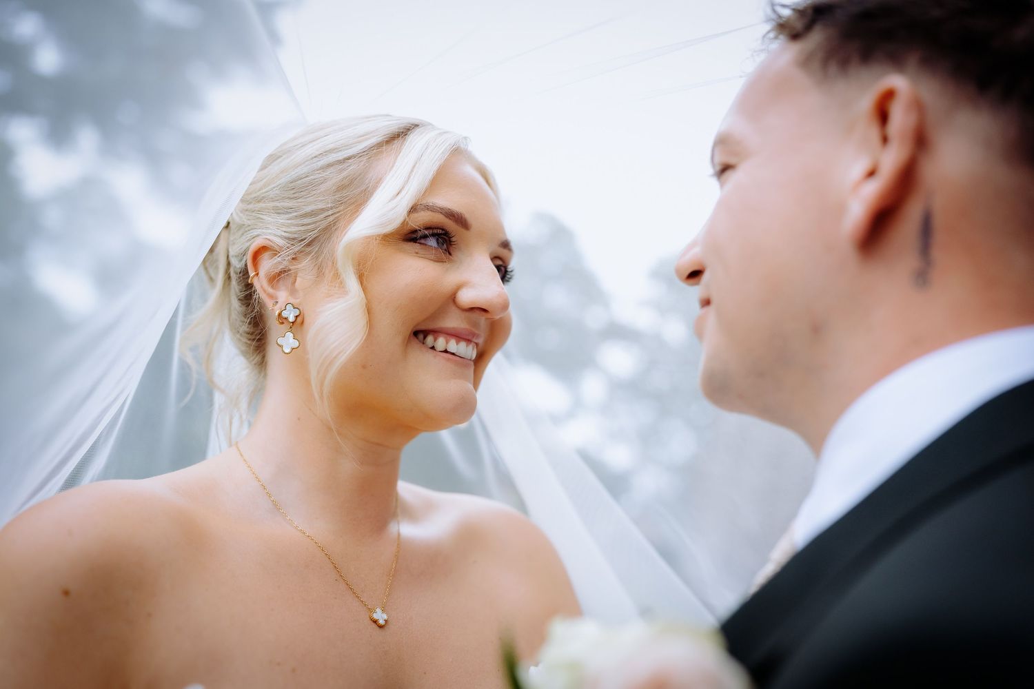 Under the veil wedding photo showing brides happy face.