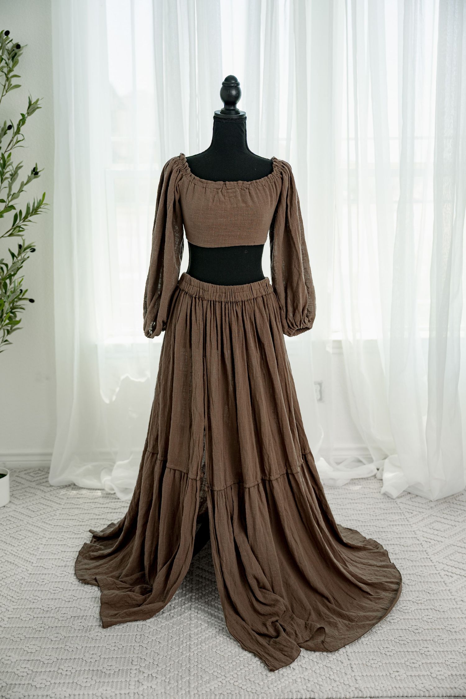 Brown two-piece set with long balloon sleeves crop top and tiered maxi skirt with train on mannequin.