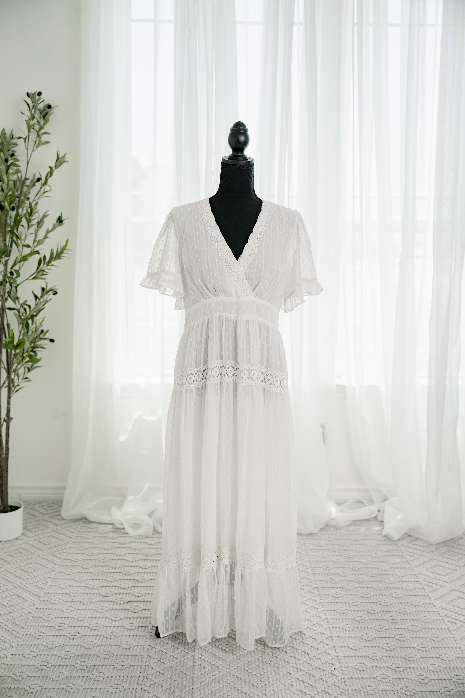 White lace V-neck flutter sleeve boho maxi dress on mannequin.