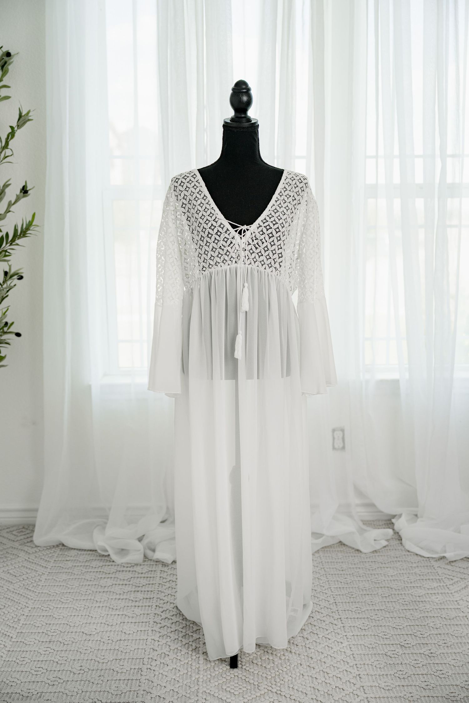 White boho lace and chiffon maxi dress with bell sleeves on a black mannequin.