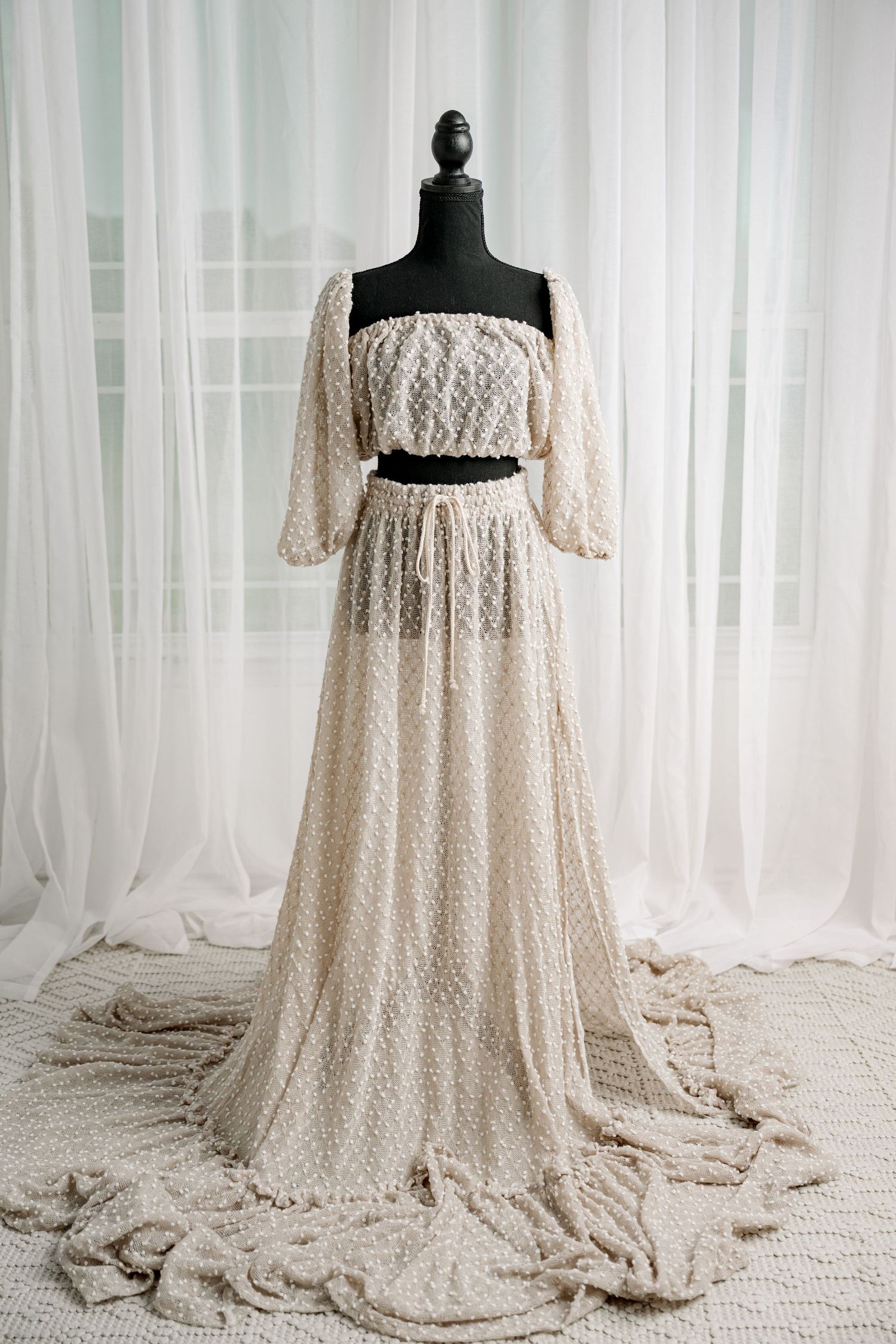 Ivory lace two-piece off-shoulder crop top and maxi skirt set on mannequin.