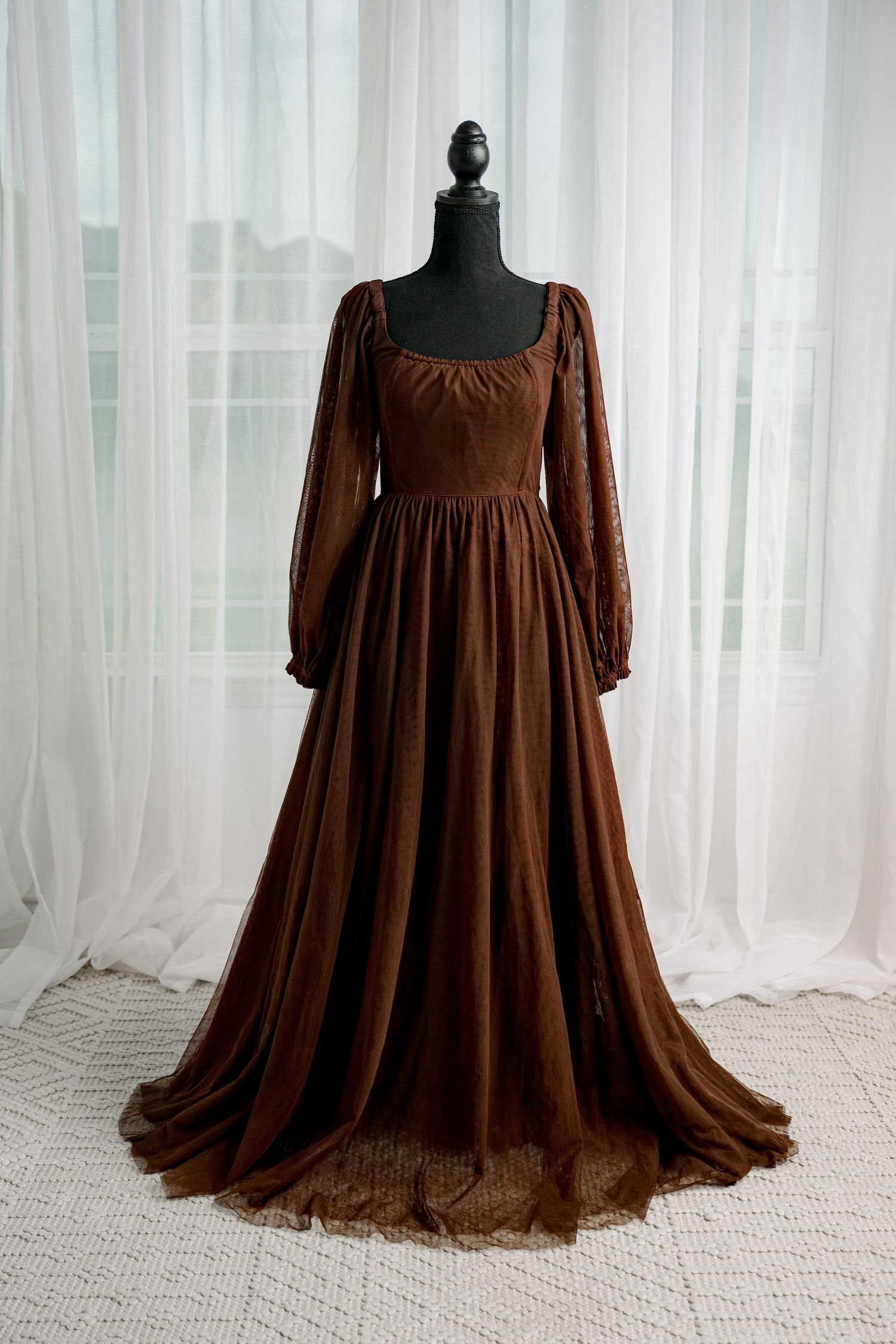 Brown long sleeve velvet gown with square neckline and full skirt on mannequin.