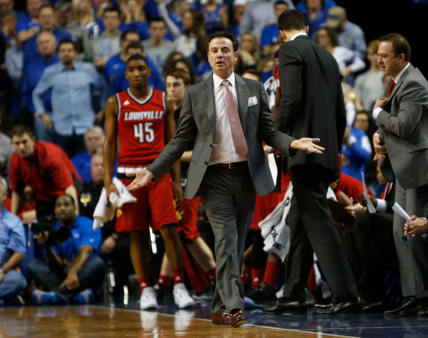 Basketball coaches and players show intense emotion during a heated game moment.