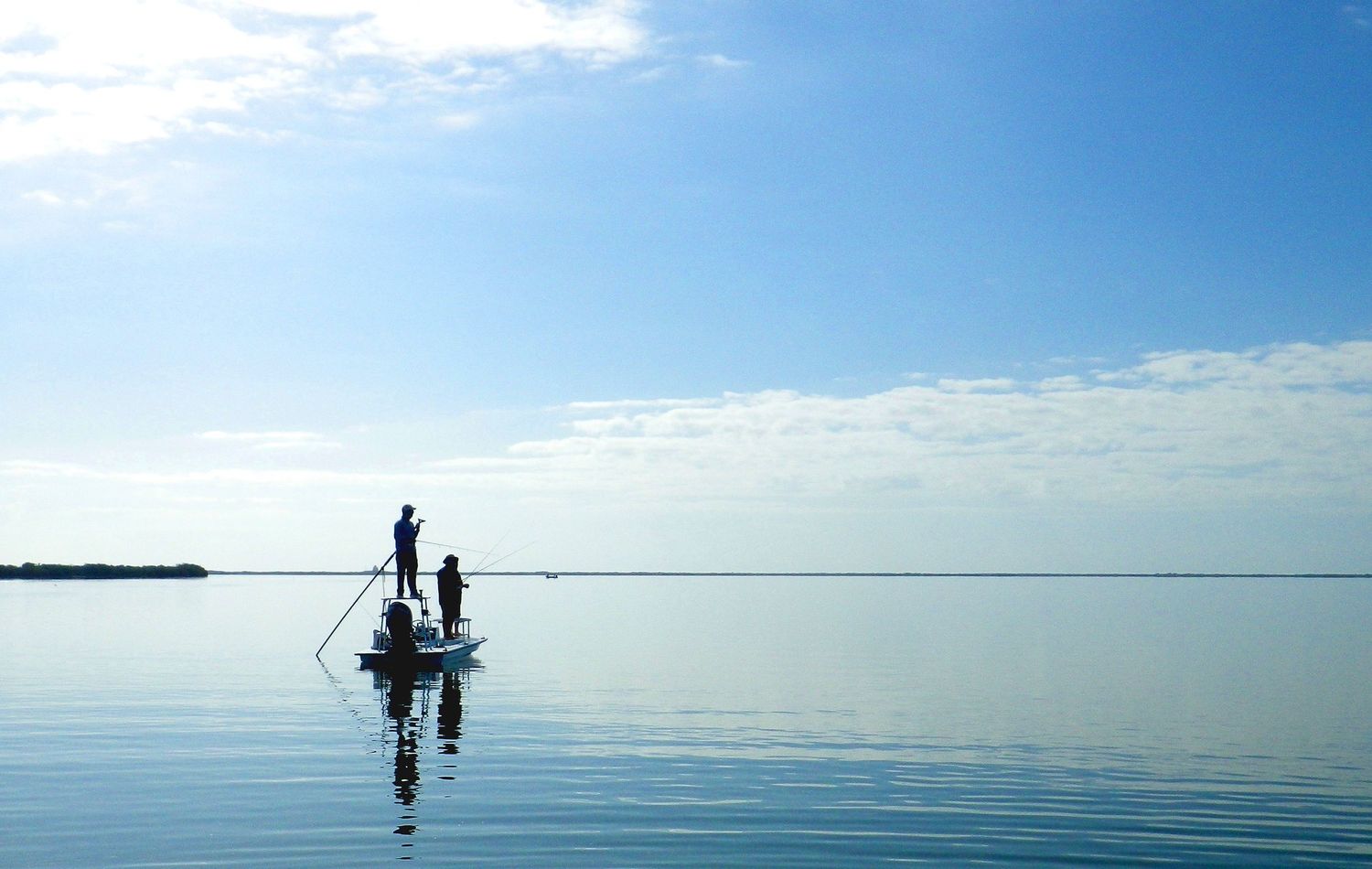 A series of panoramic photos showing people silhouetted against a calm ocean horizon under bright blue skies.